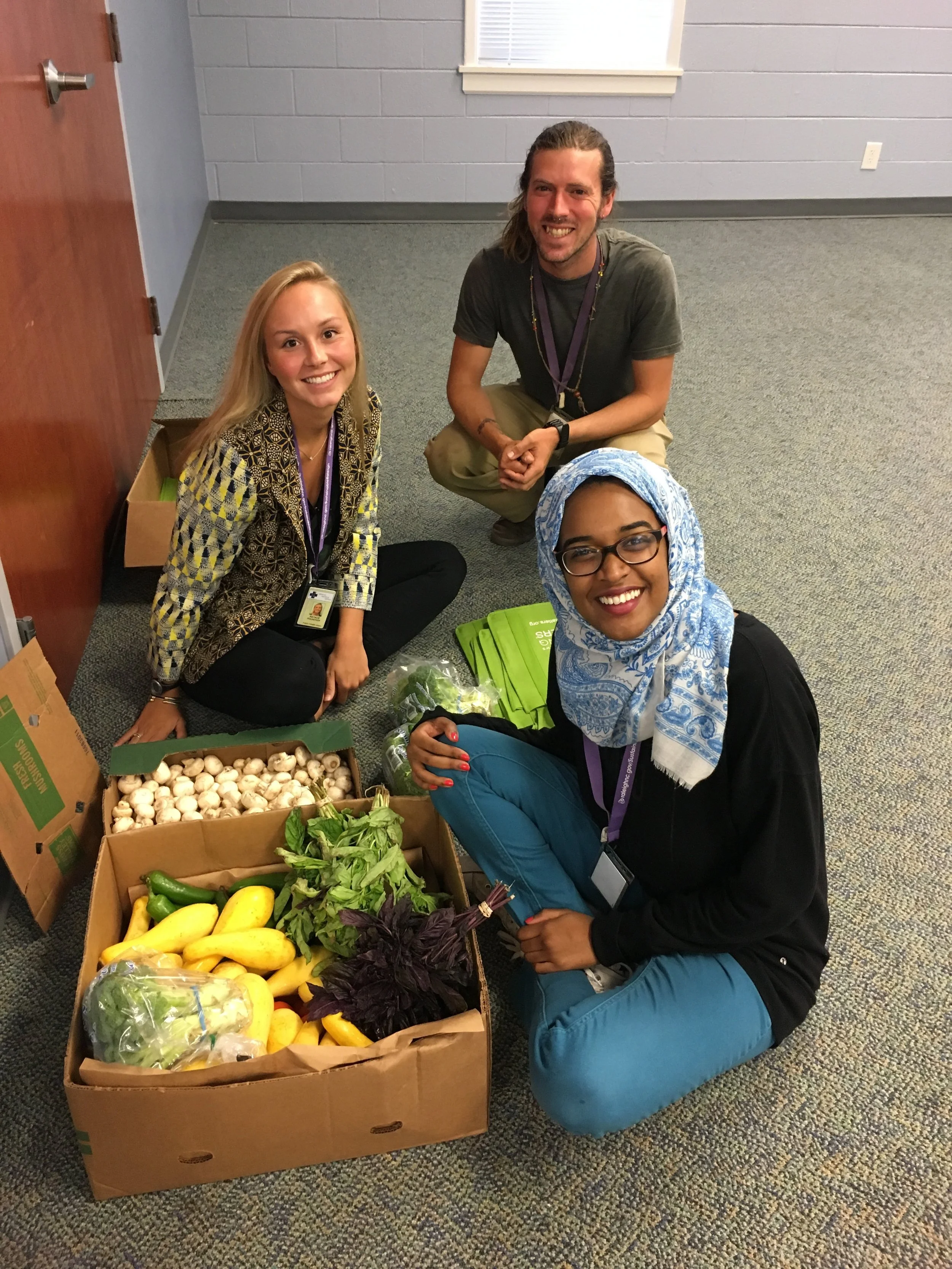L to R: Natalie Holdstock, Garden & Wellness Coordinator Jesse Crouch, and Doha Medani helping fill bags of produce for Cooking Matters participants to take home.