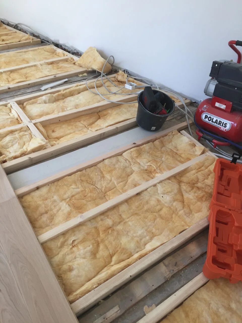 Opretning af bjælkelag og montering af massiv eg plank med lyddæmpning med gips og fuge