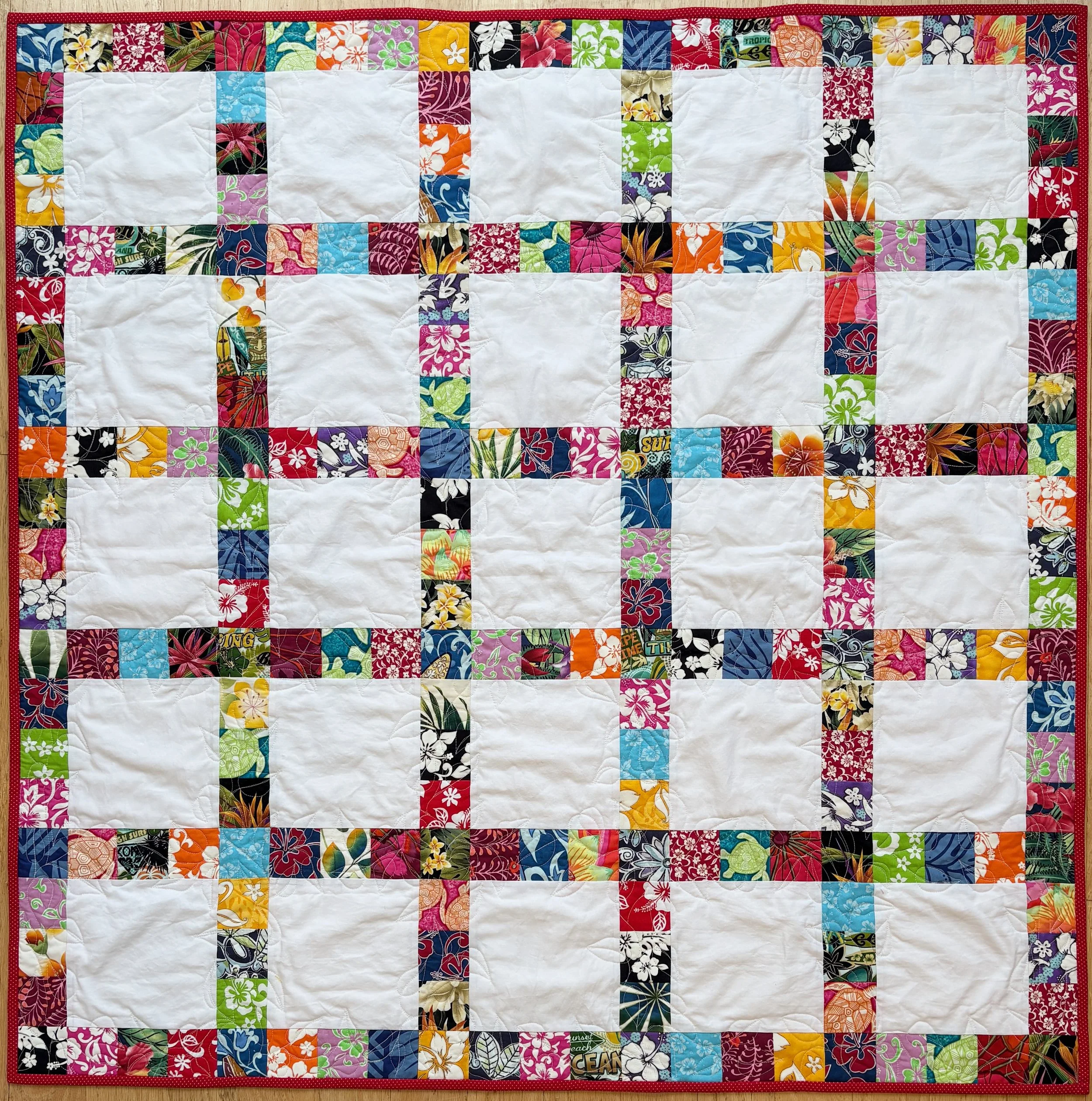 Quilt with Hawaiian fabrics as surrounding squares