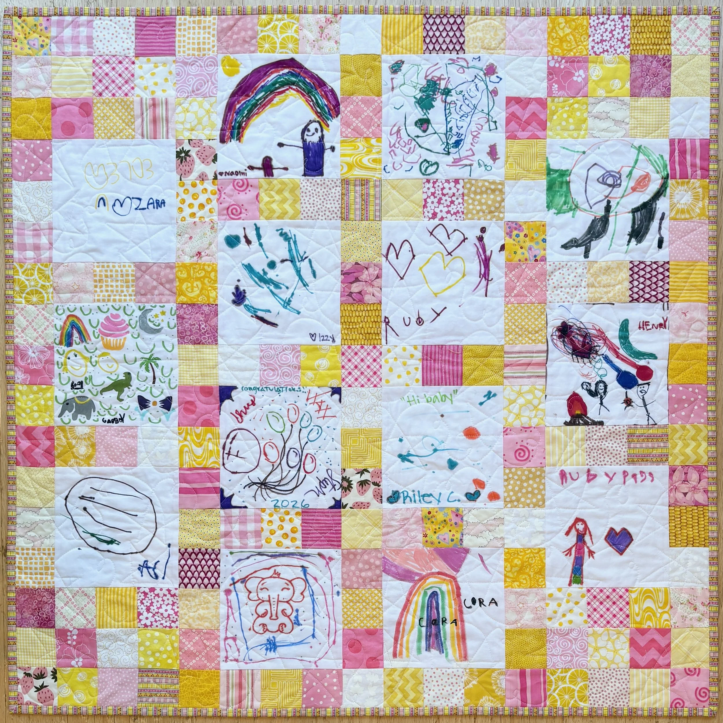 Quilt with pink, yellow and white fabrics as surrounding squares