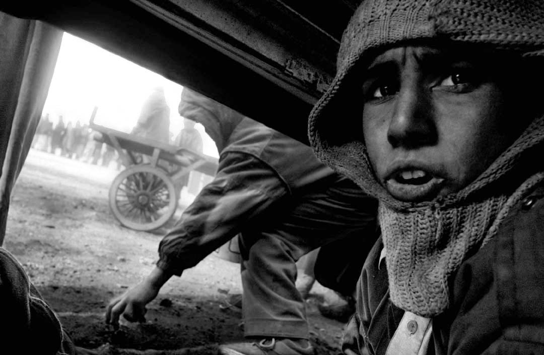 Children collect scraps of coal at an aid distribution site. Kabul, Afghanistan 2002