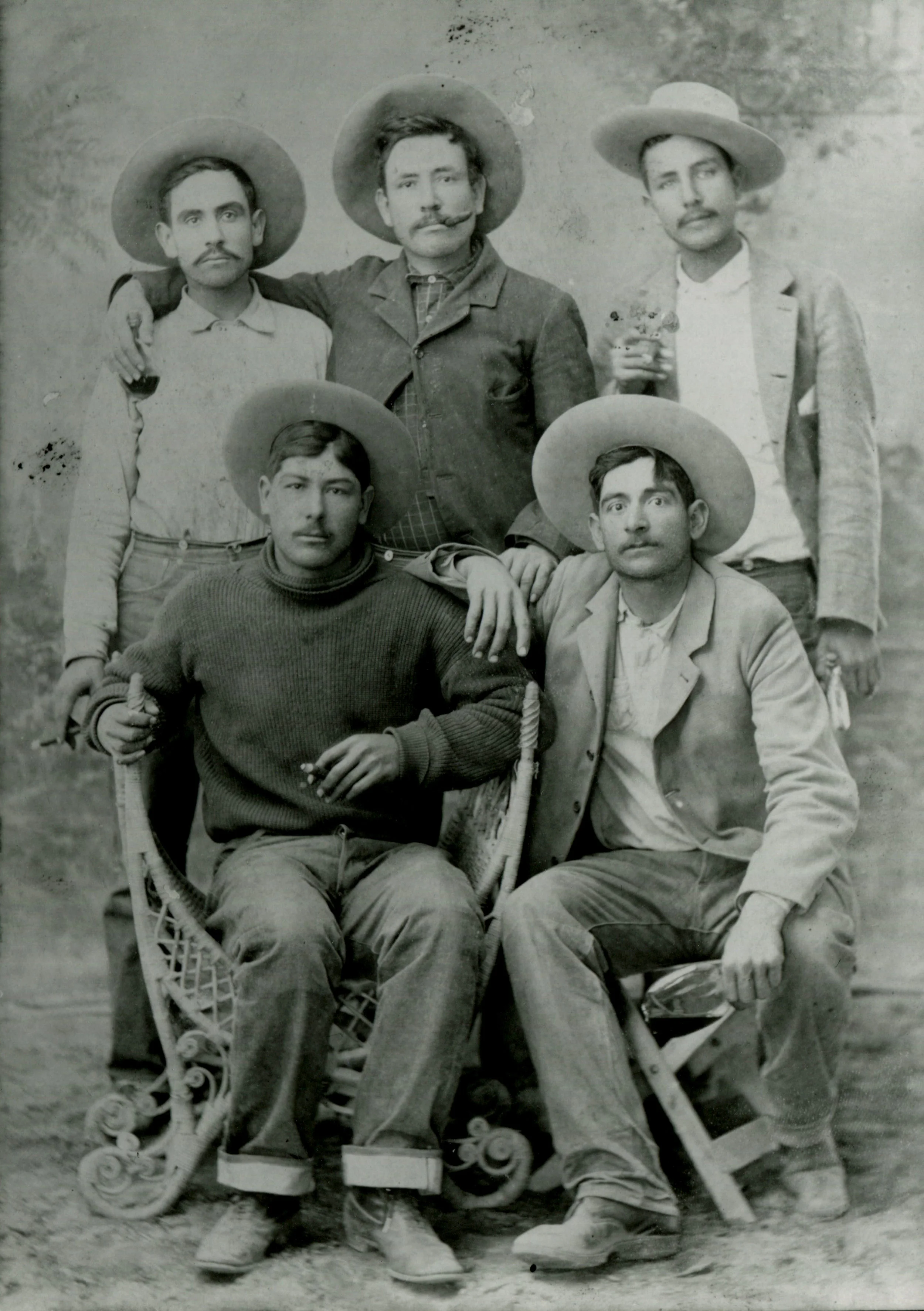 The writing on the back of this photograph reads: 1897 "Chano" Amigo. Francisco Andrade, Ramon Andrade, Unknown. If you look closely you can notice each of them has either a flask or a cigar in hand. It was very common for photographers back in the day to have their subjects hold props. In some old photographs you will see gown men holding children's toys. 