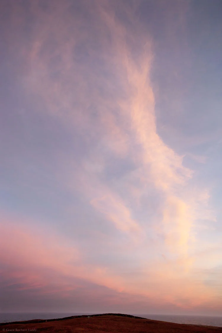 The wind had blown the fog into vertical streams that caught the setting sun. 