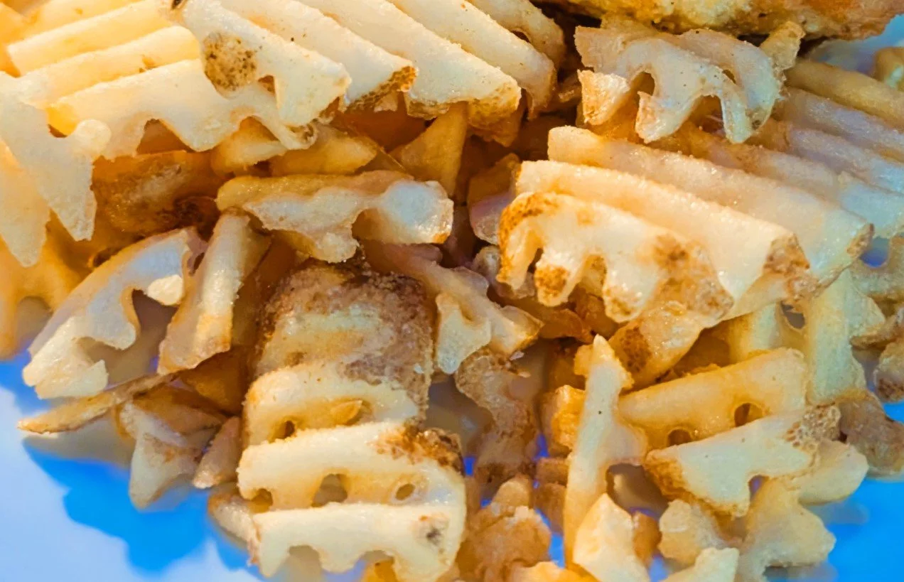 Close-up of crispy waffle fries with a golden-brown color.