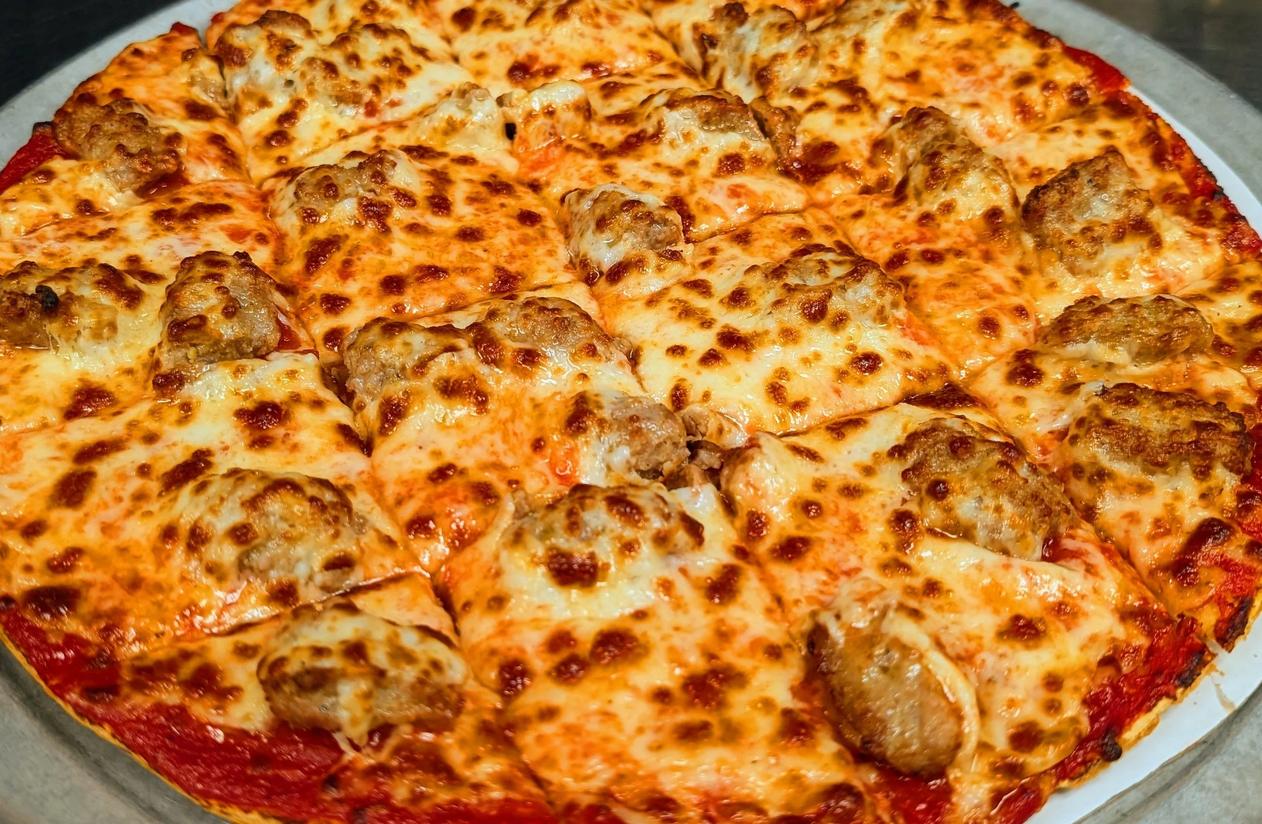 Close-up of a freshly baked meatball pizza with melted cheese and tomato sauce