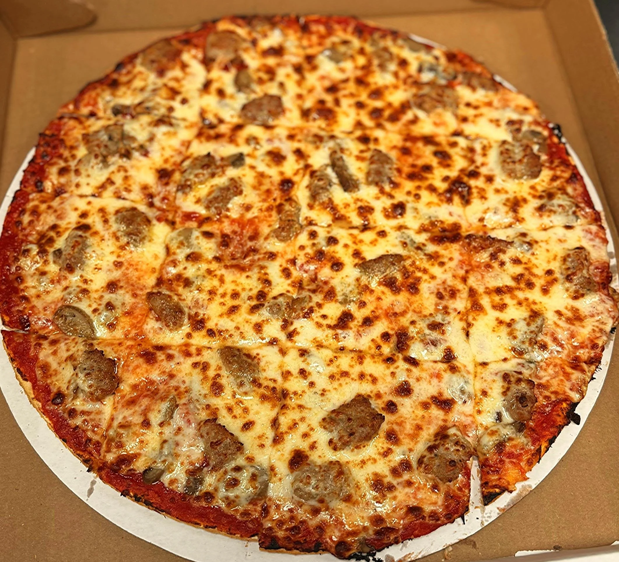 Cheeseburger pizza with beef, cheese, and melted cheese in a cardboard box