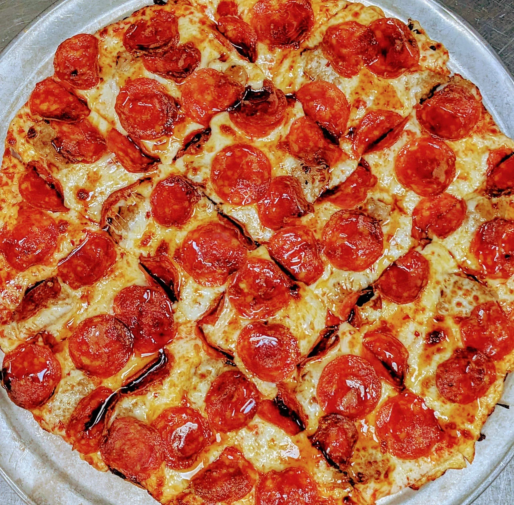 A round pizza with pepperoni slices and melted cheese.