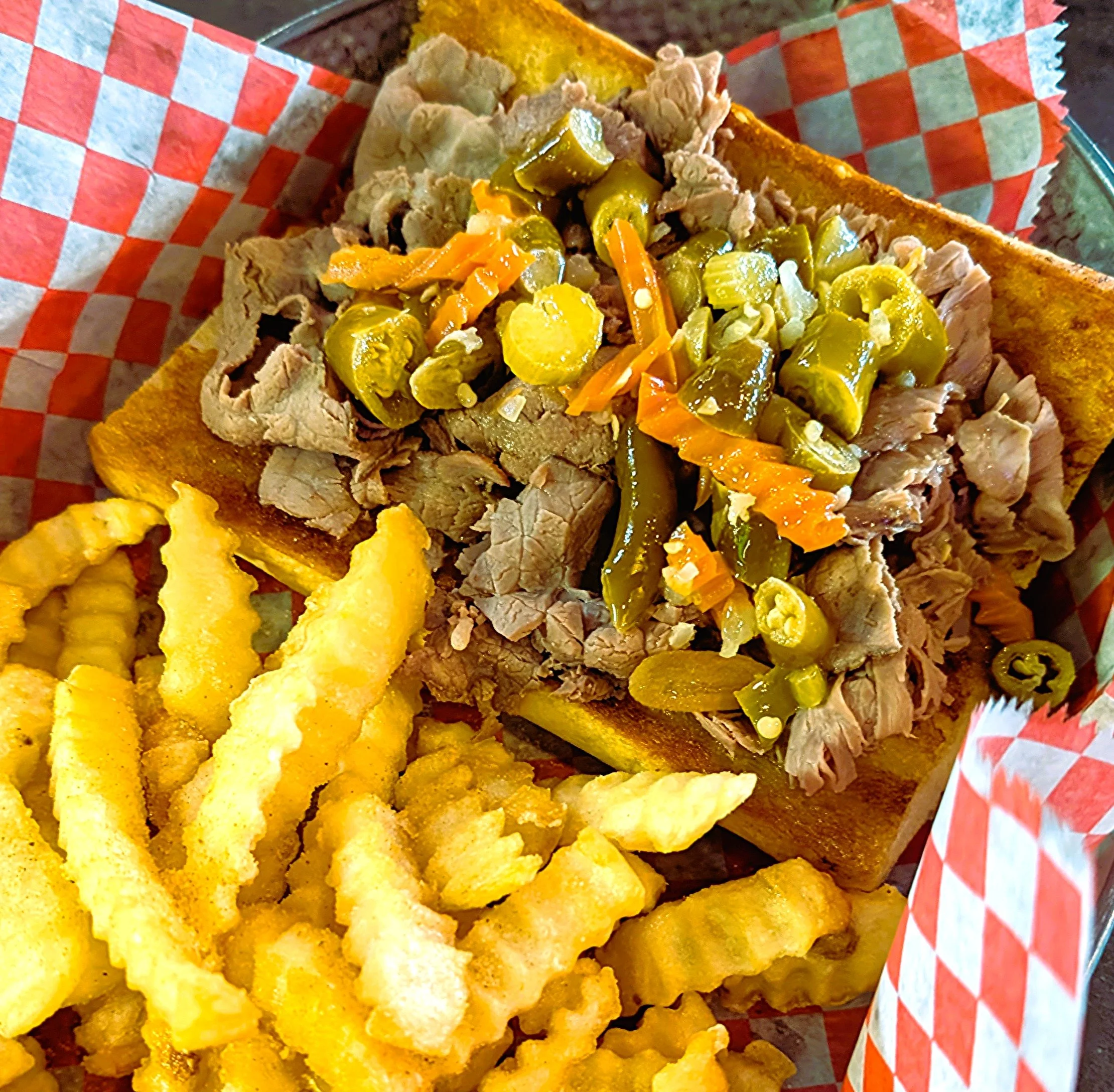 Chopped pork topped with pickled jalapeños and shredded carrots on toast, served with crinkle-cut French fries.