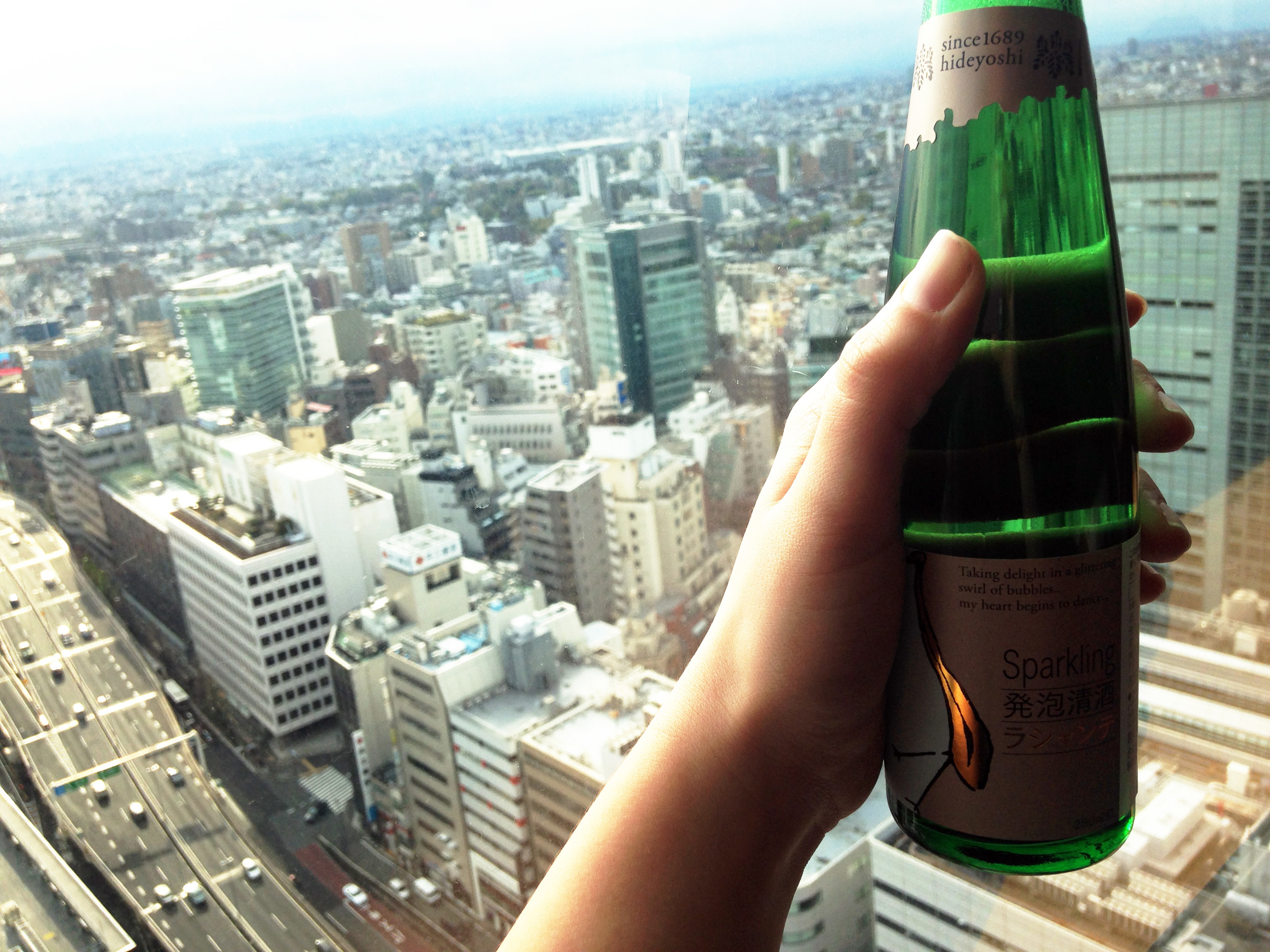 Hanging out in the hotel window, in Shibuya, with Sake i brought back from Akita.