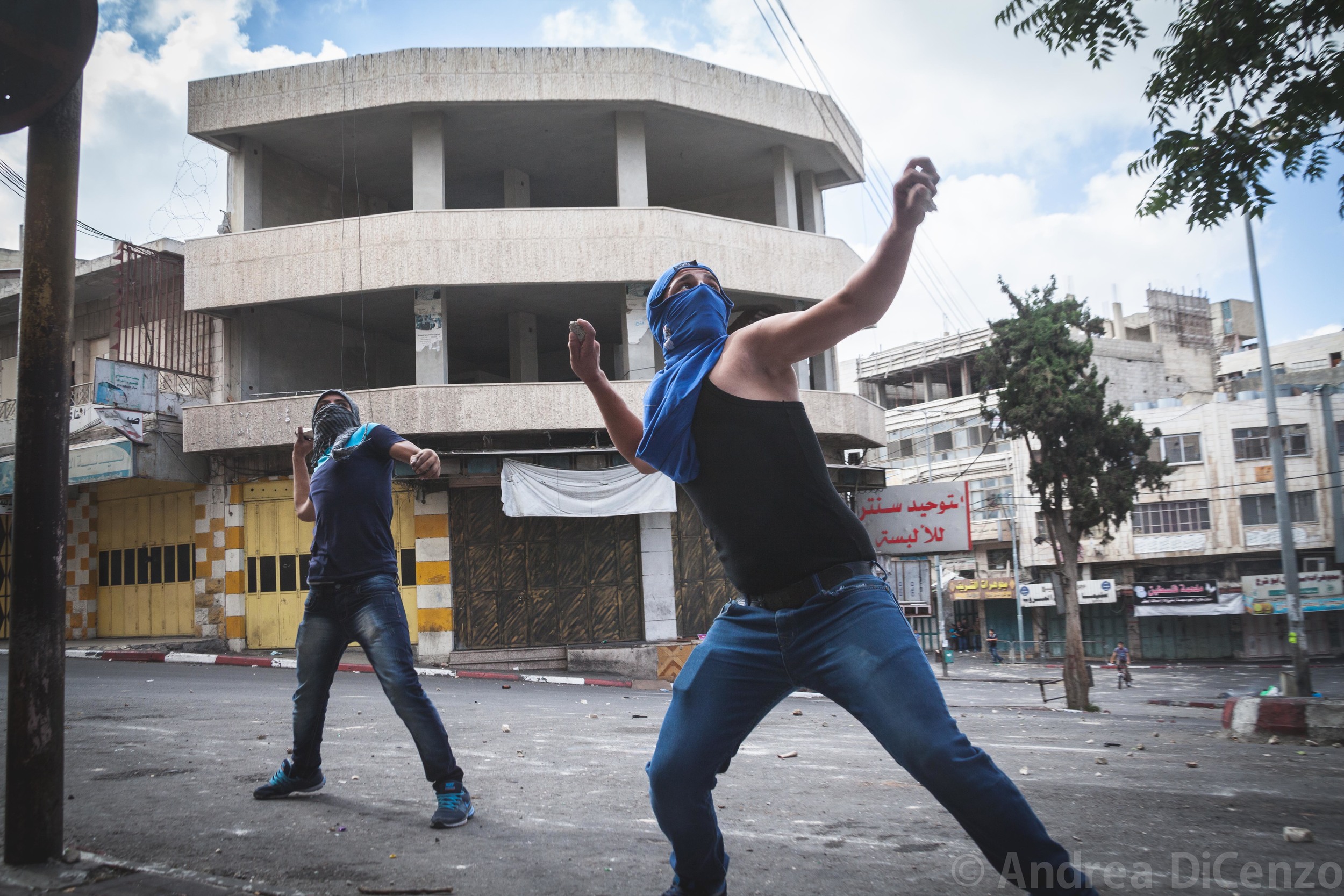  Young men throw rocks at the Israeli Defense Forces in a violent clash in Hebron, West Bank.&nbsp; 