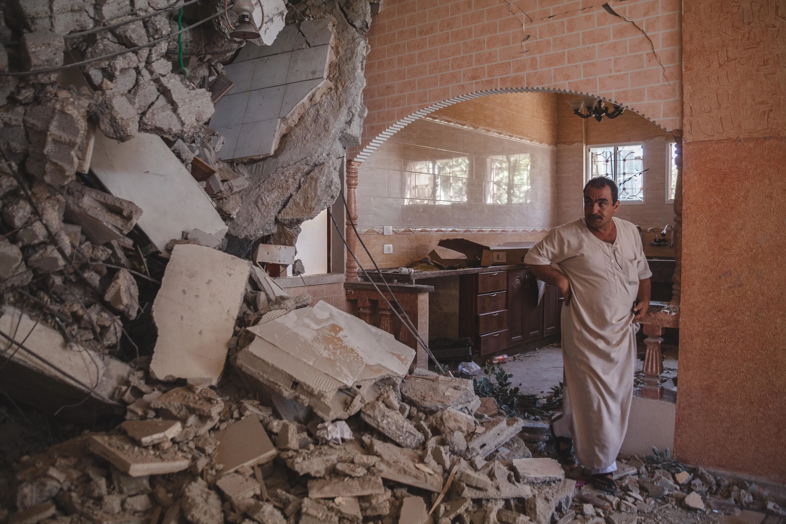 Inspecting the extent of the damage to his home, residence of Gaza City has now relocated his family to the house of a distant relative. The damage is to sever to repair the house as it stands. The family will have to knock down the remaining structure to start again. Gaza City, Gaza.