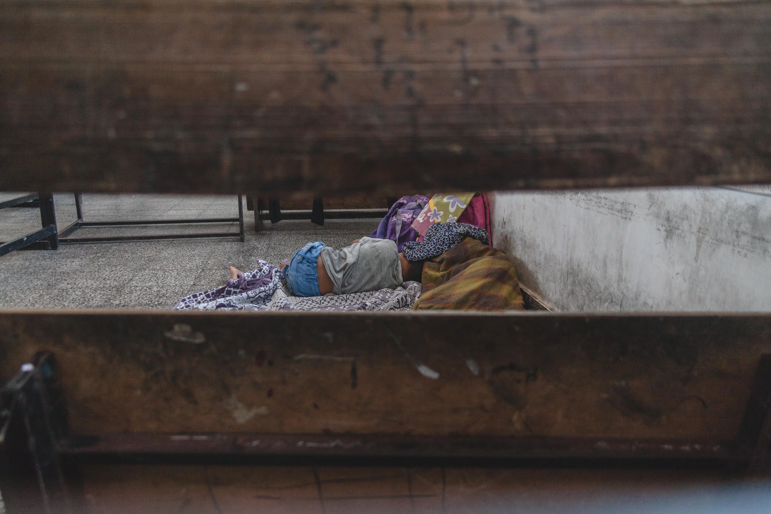 A child sleeps on the floor of a UN school, which has become his temporary home. An estimated 65,700 people have been displaced and are staying in shelters like these according to the UNRWA.