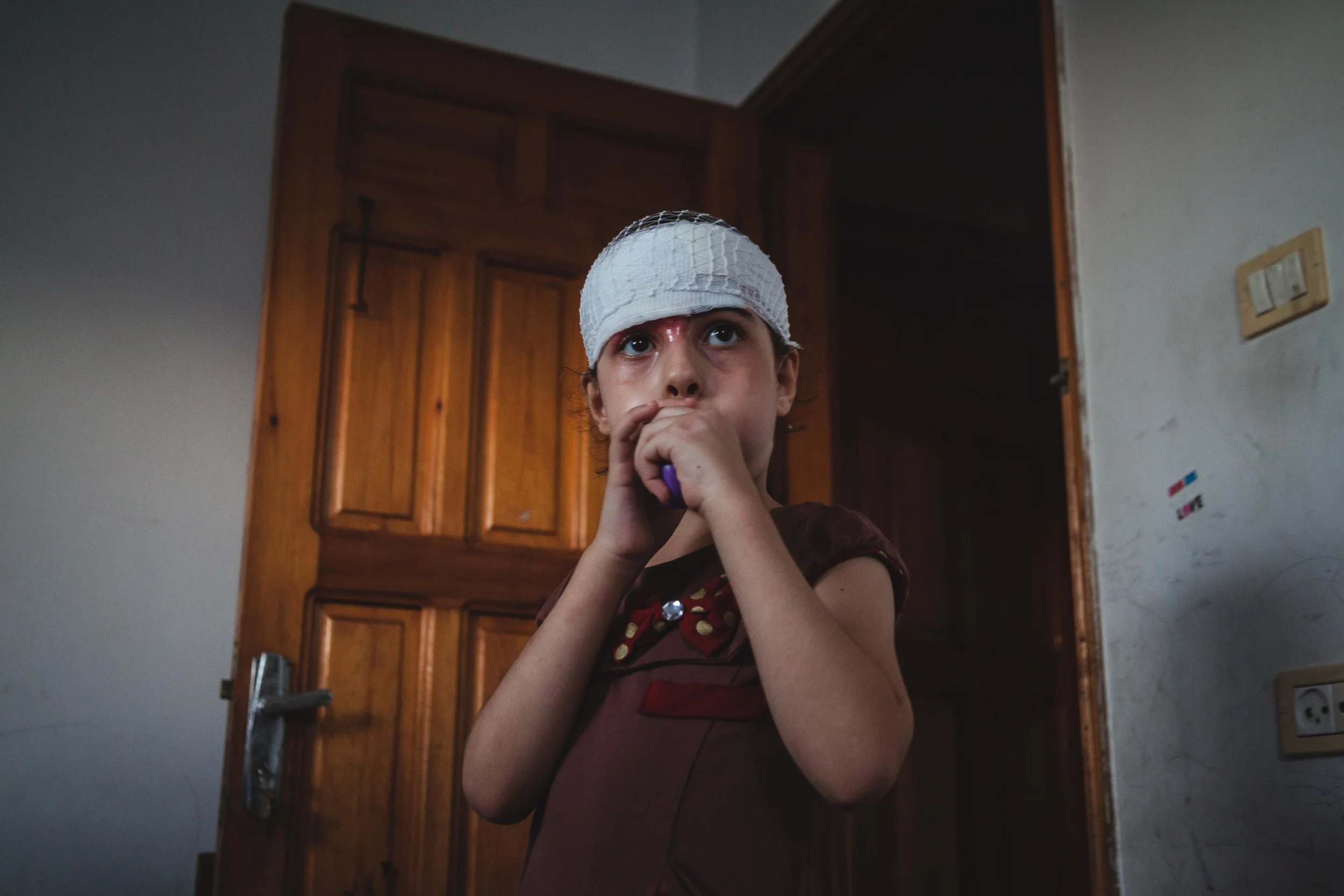 A quieter, more subdued Besan plays with a balloon in her new bedroom at her older sister’s house. Gaza City, Gaza.
