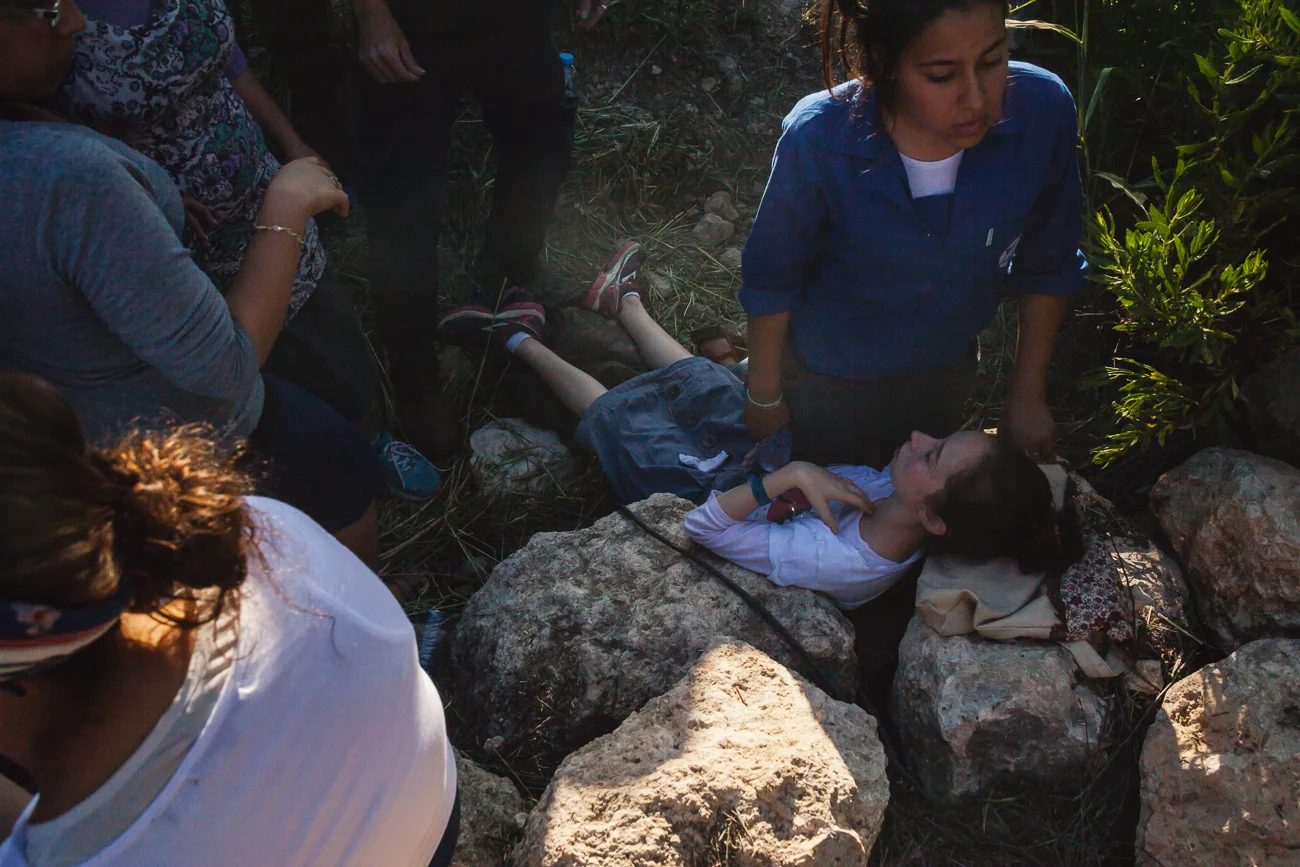A child faints from the overbearing heat and dense crowd during the state funeral for the three murdered Israeli teenagers. 1 July 2014.