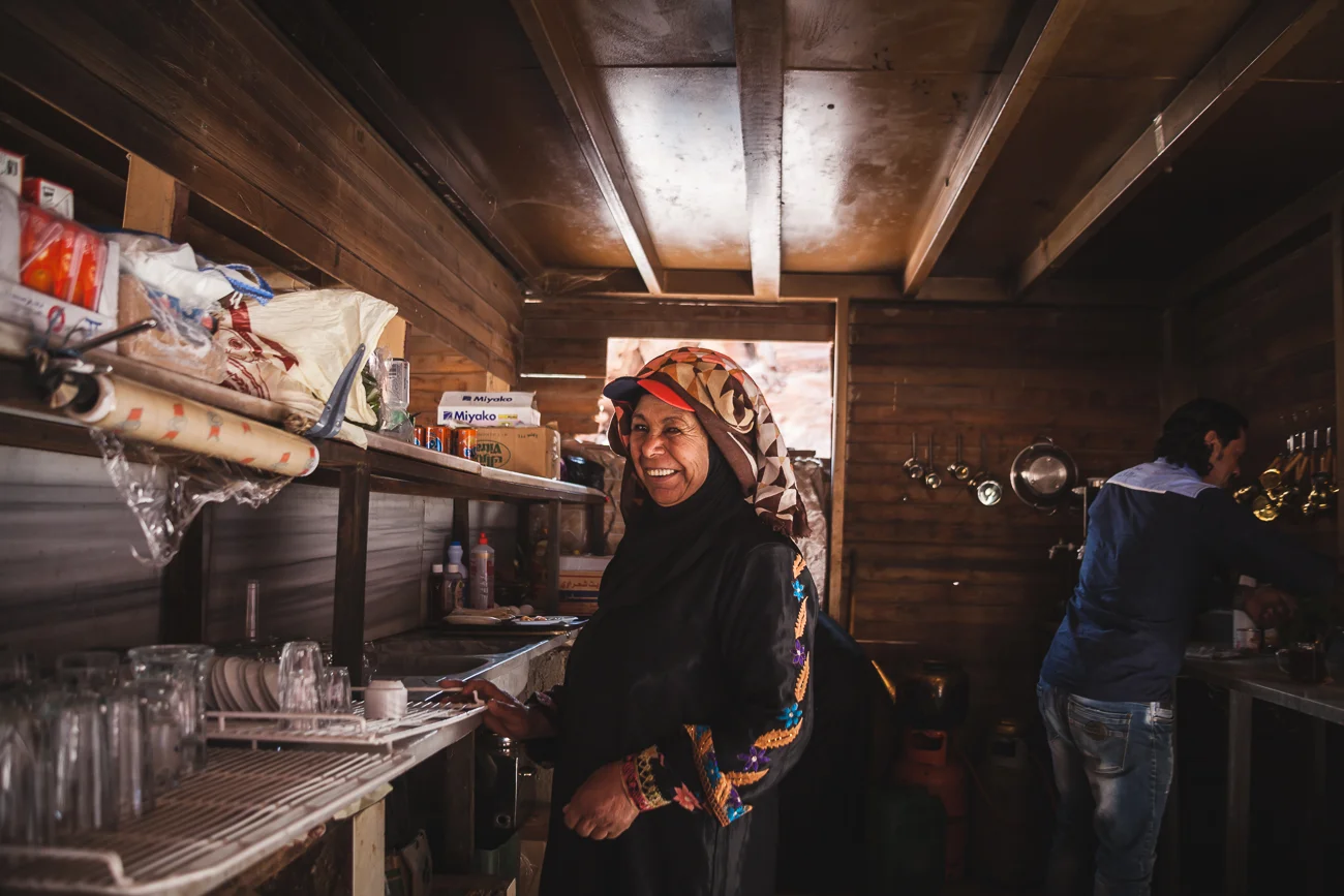 A women smile as she prepares traditional tea.