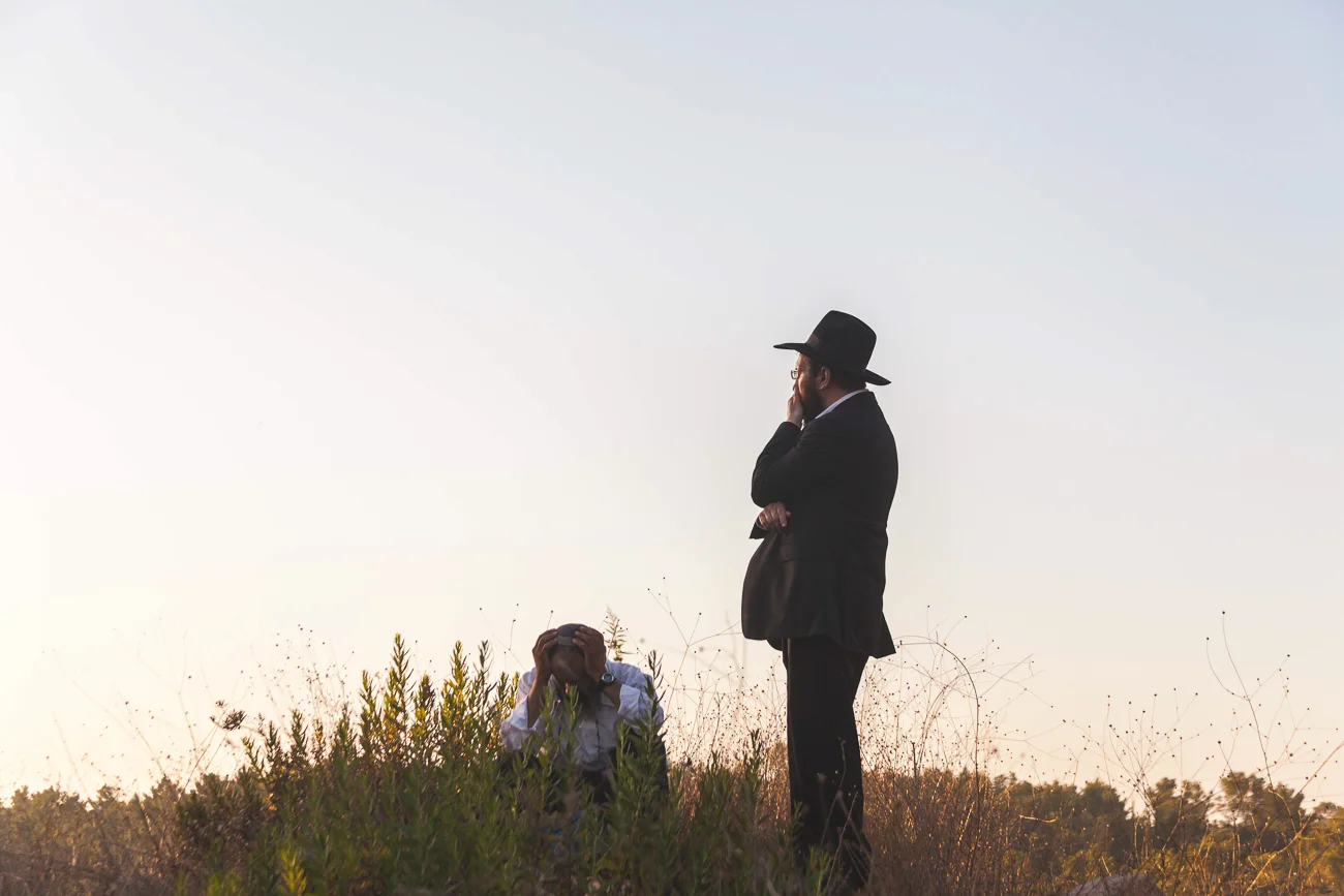 Mourners look off into the distance at the state funeral of the three murdered Israeli teenagers - Naftali Fraenkel, Gilad Shaer, and Eyal Yifrah.