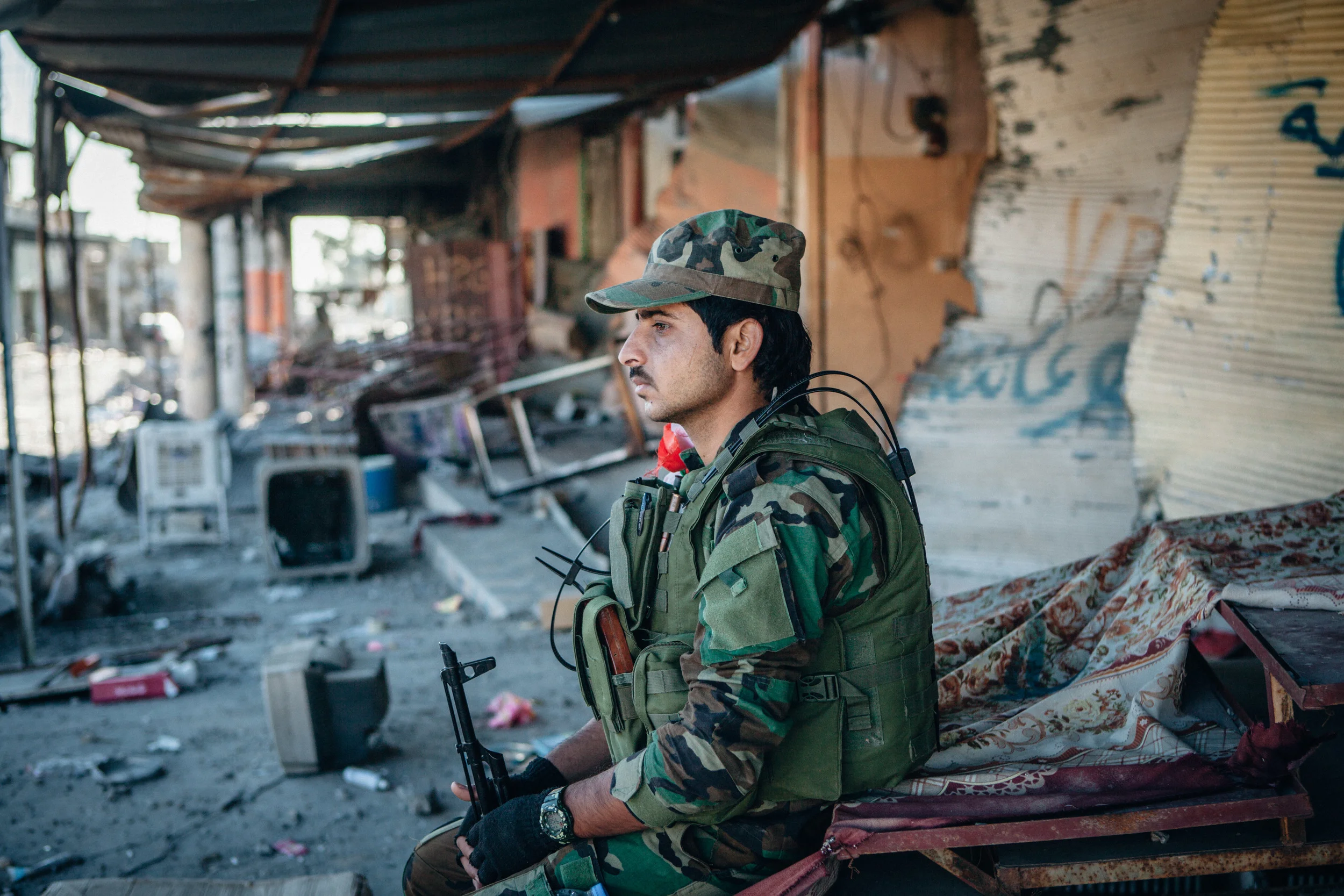 Peshmerga solider sits alone on the street.