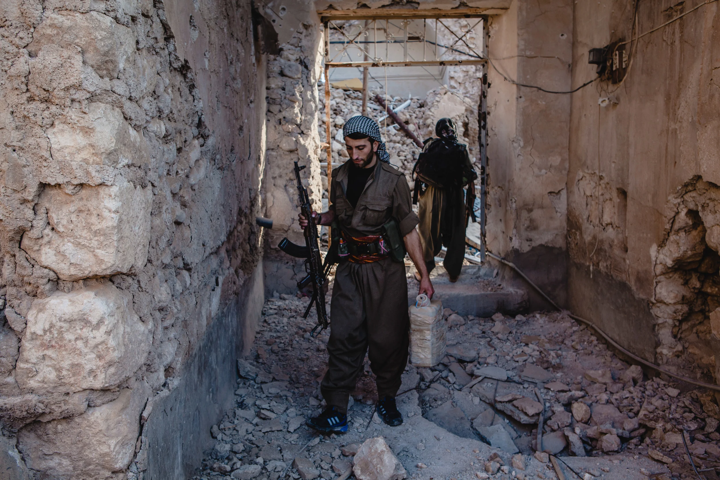 PKK units remove an explosive hidden in the front passage way of one of the cities houses.