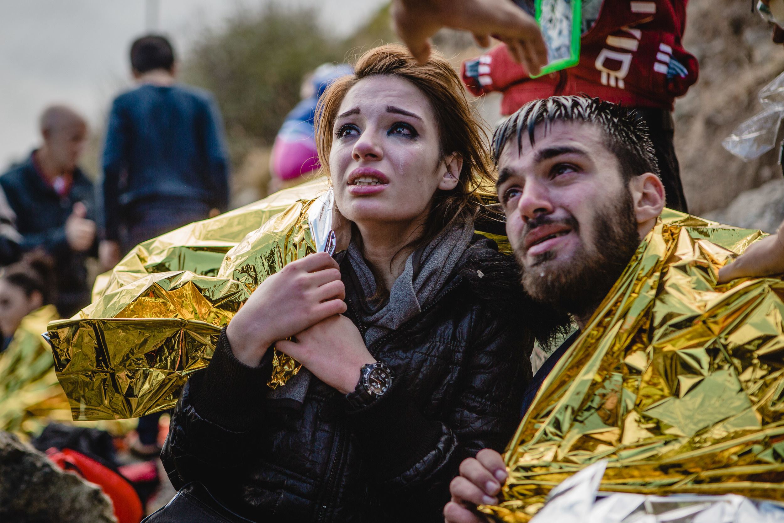  Migrants react after arriving on the shore of the Greek island of Lesbos. 