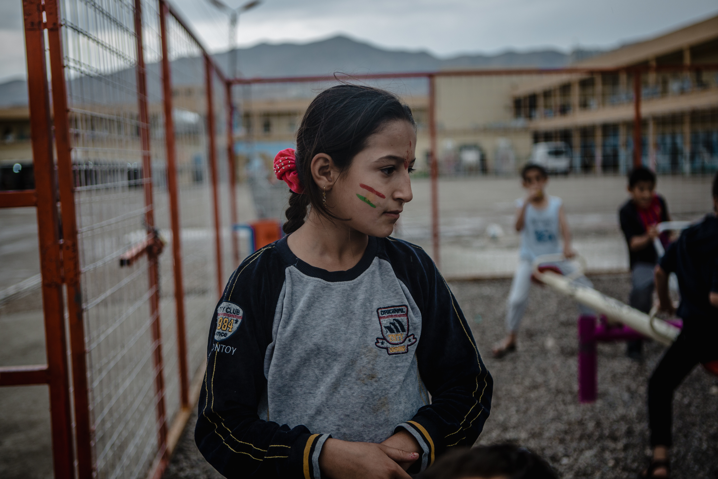 A young Syrian girl with face paint plays in the playground built for the camp.