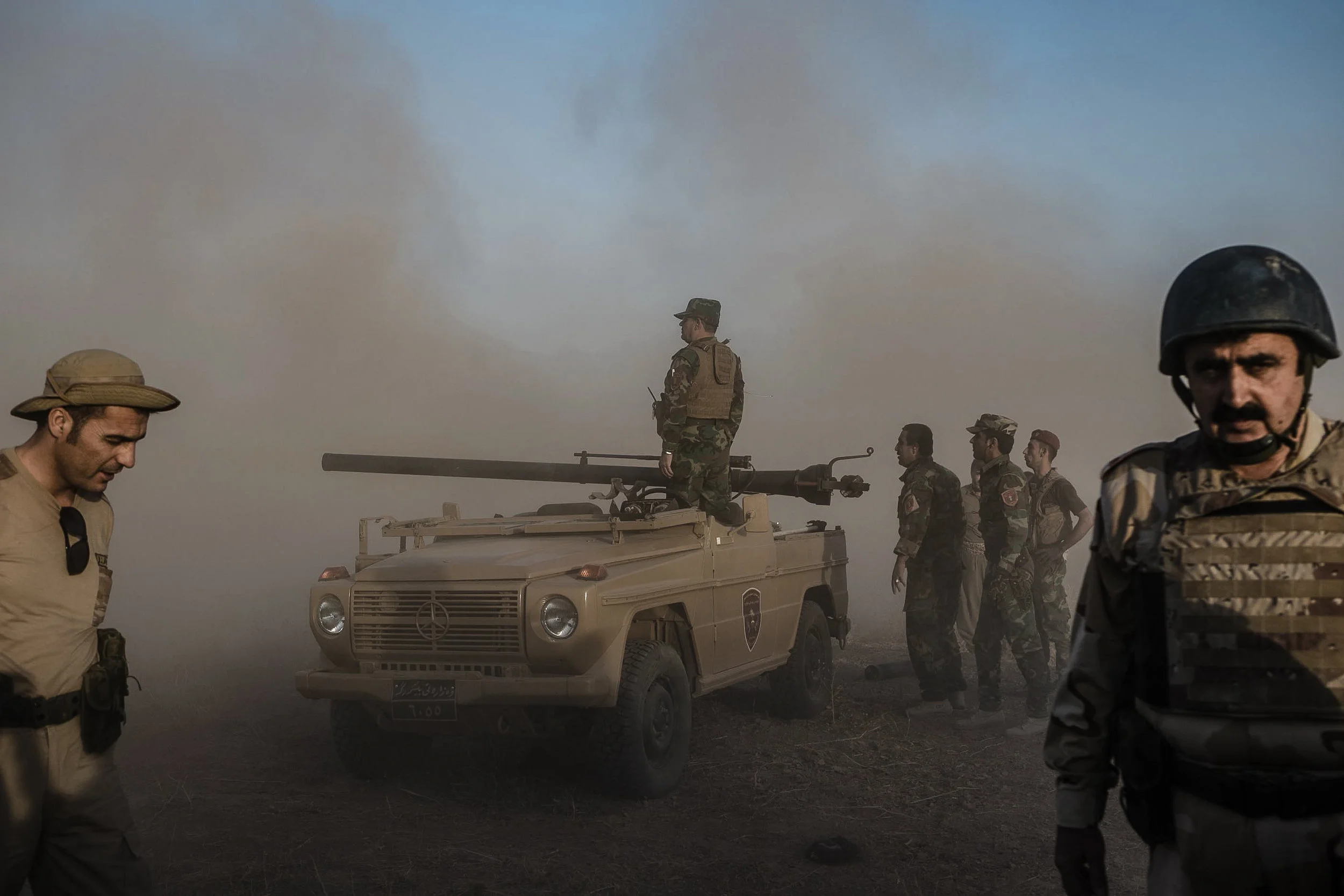 Dust kicked up from a discharged missile launcher clears around the Iraqi Peshmerga forces as they watch to see where the rocket landed during one of their offensives to retake territory from the Islamic State. The Iraqi Peshmerga have been one of the most successful fighting forces against the Islamic State in Iraq, holding a 700-mile frontline from the Syrian to Iranian border. Subsequently the force has also extended Kurdish controlled territory by 50% as they clear areas occupied by the Islamic State in northern Iraq.