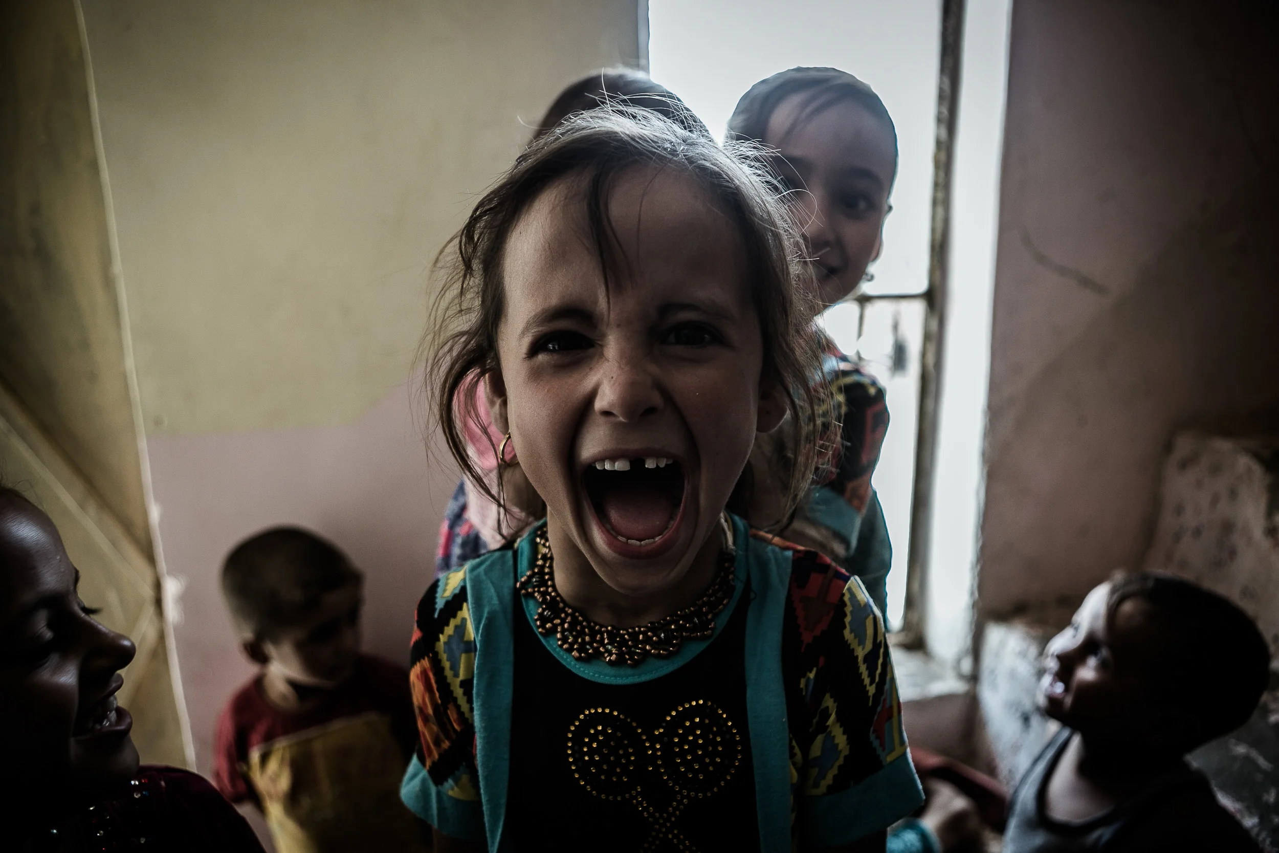 A young girl screams in excitement to her photo being taken. After living under Islamic State occupation, her village was retaken by the Iraqi Army in the summer 2016.