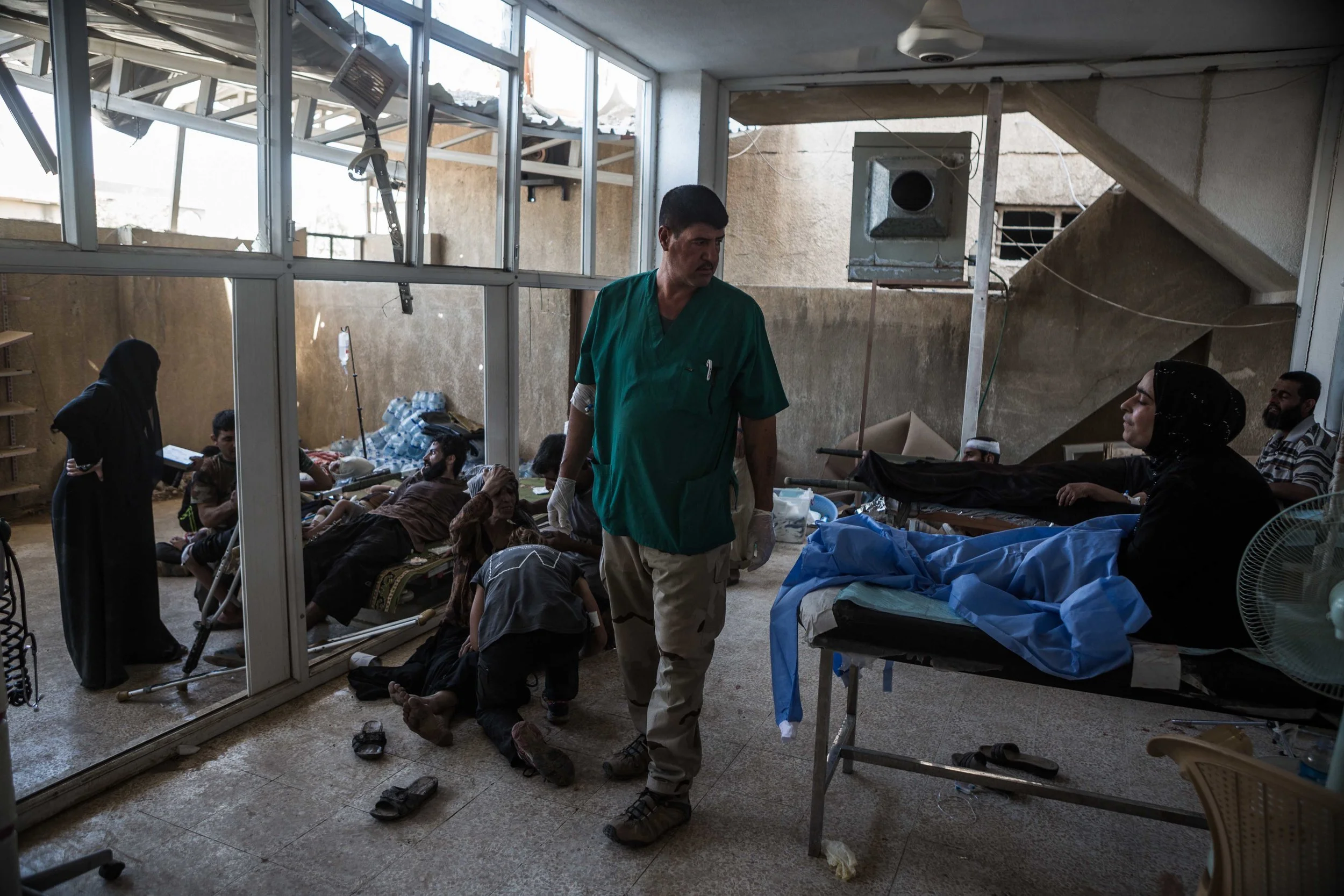 At a mosque-turned-field clinic in Al-Rabi'ah nieghborhood, west Mosul, a medic from the Iraqi army 9th division looks around at the influx of injured civilians his clinic received after a mortar hit a group of civilians that were attempting to flee fighting between Iraqi forces and the Islamic State militants. As the end of the nine-month battle drew closer, civilians were targeted with much greater frequency by the extremists. 