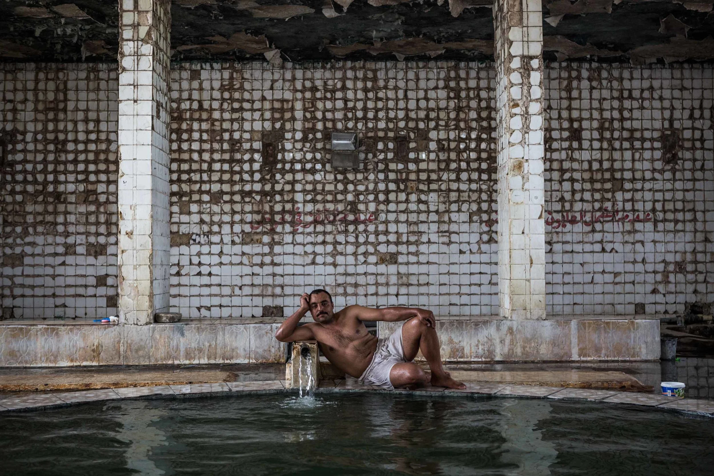 An Iraqi man relaxes in the baths of Hammam al-Alil. Since the baths reopened in November, it’s been used by townspeople as well as members of the Iraqi army and civilians displaced by fighting. The town gets its name from natural sulphur springs that are used in the baths.