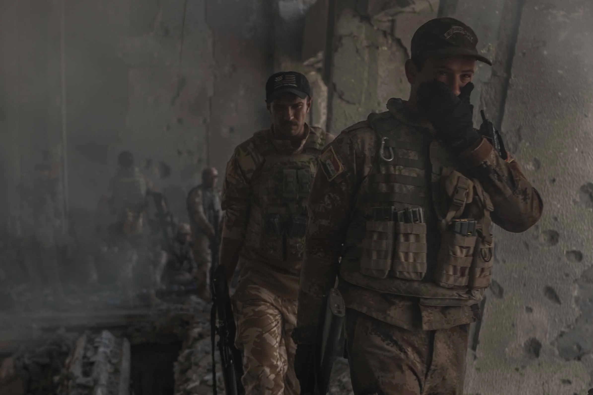 An Iraqi solider covers his month from smoke after Islamic State mortars set parts of the building on fire earlier in the day.