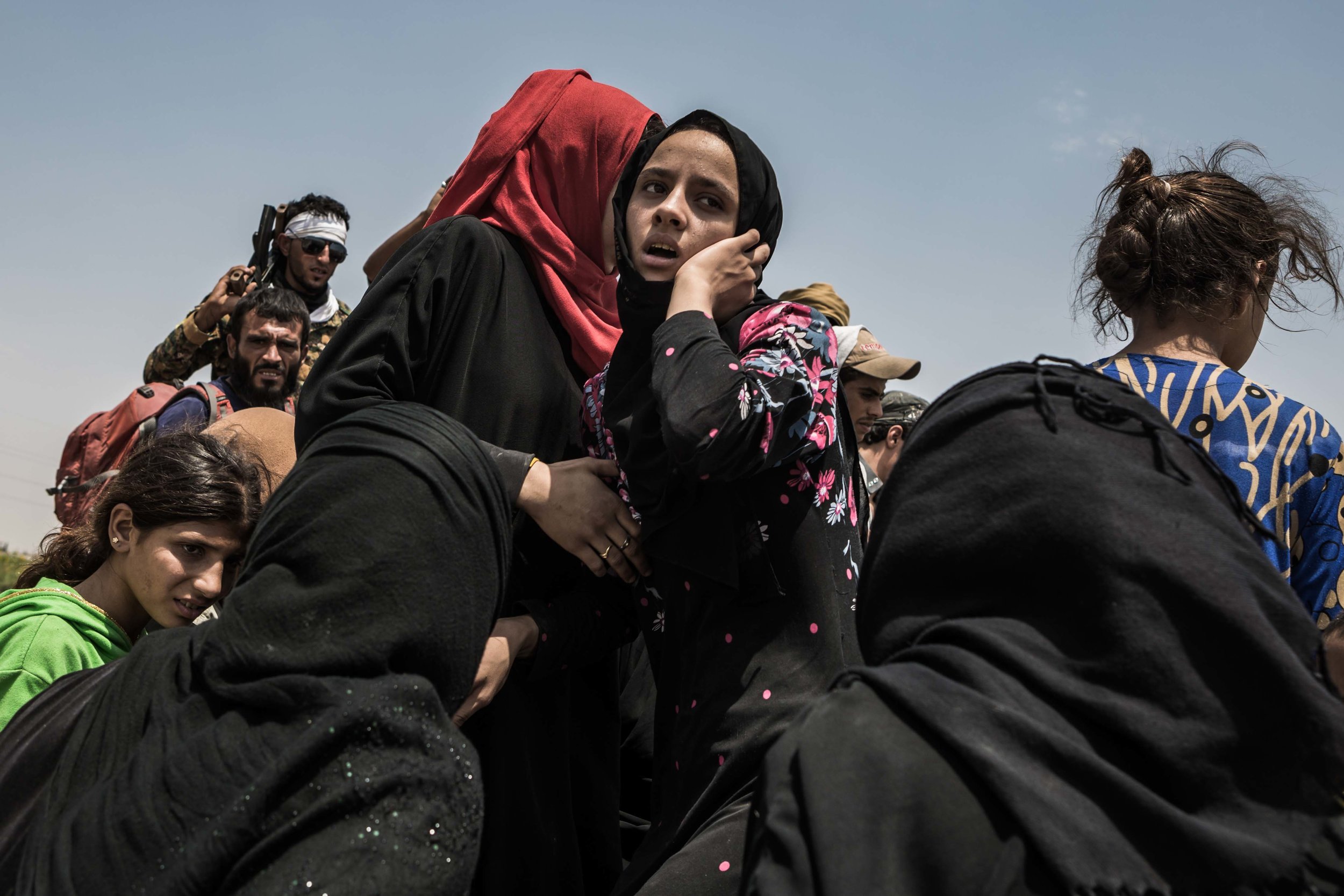  After fleeing Raqqa, about three hundred civilians wait for Syrian Democratic Forces to return their identification cards and for transportation to refugee camps.

 