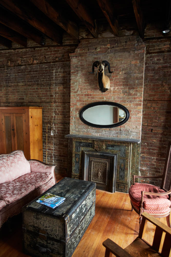 Taxidermy and an antique mirror on display over the fireplace in the Bowler. 