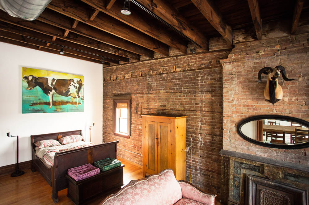 The Bowler bedroom, furnished with a sleigh bed, vintage furniture, and original artwork.