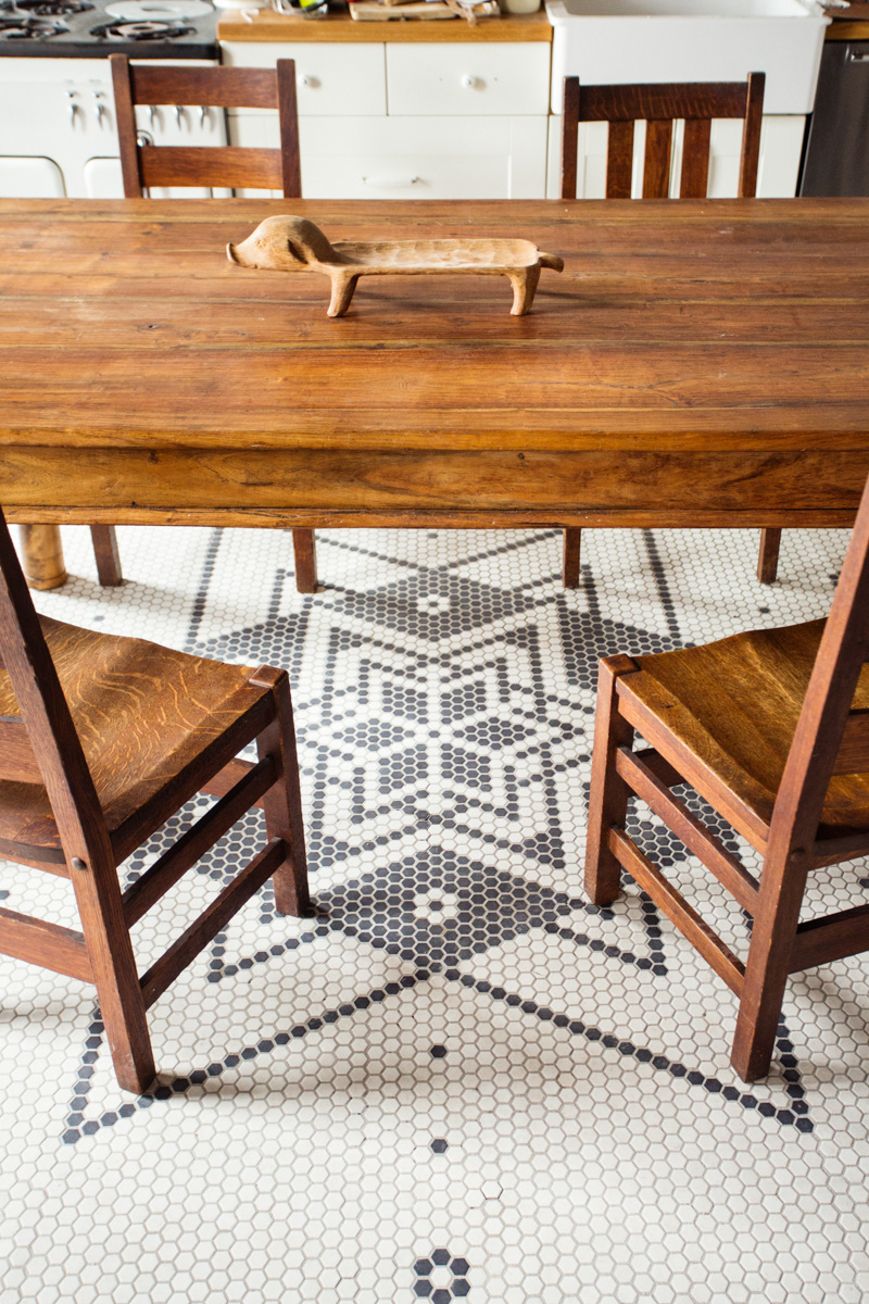 A vintage farm-style dining table sits on originally-designed octagon tile floors.