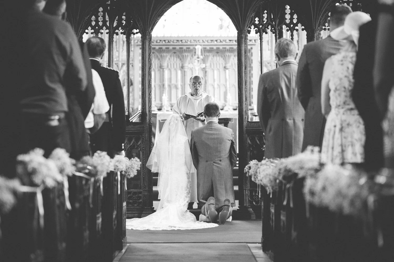 bride and groom kneeling during church ceremony