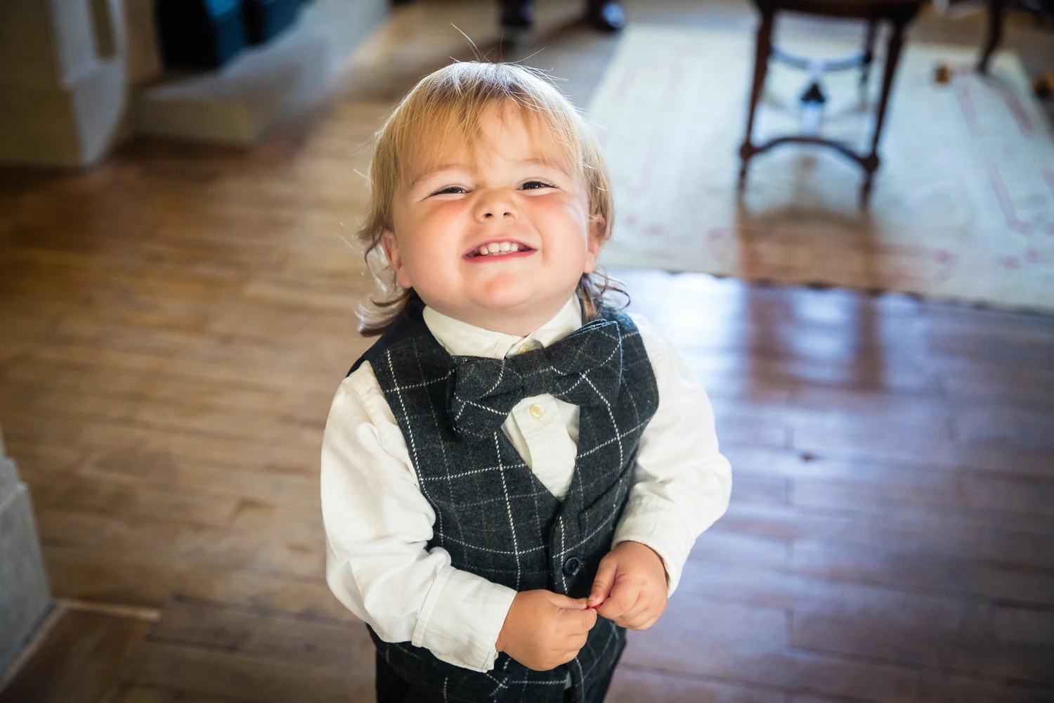 page boy in his wasitcoat smiling at the camera