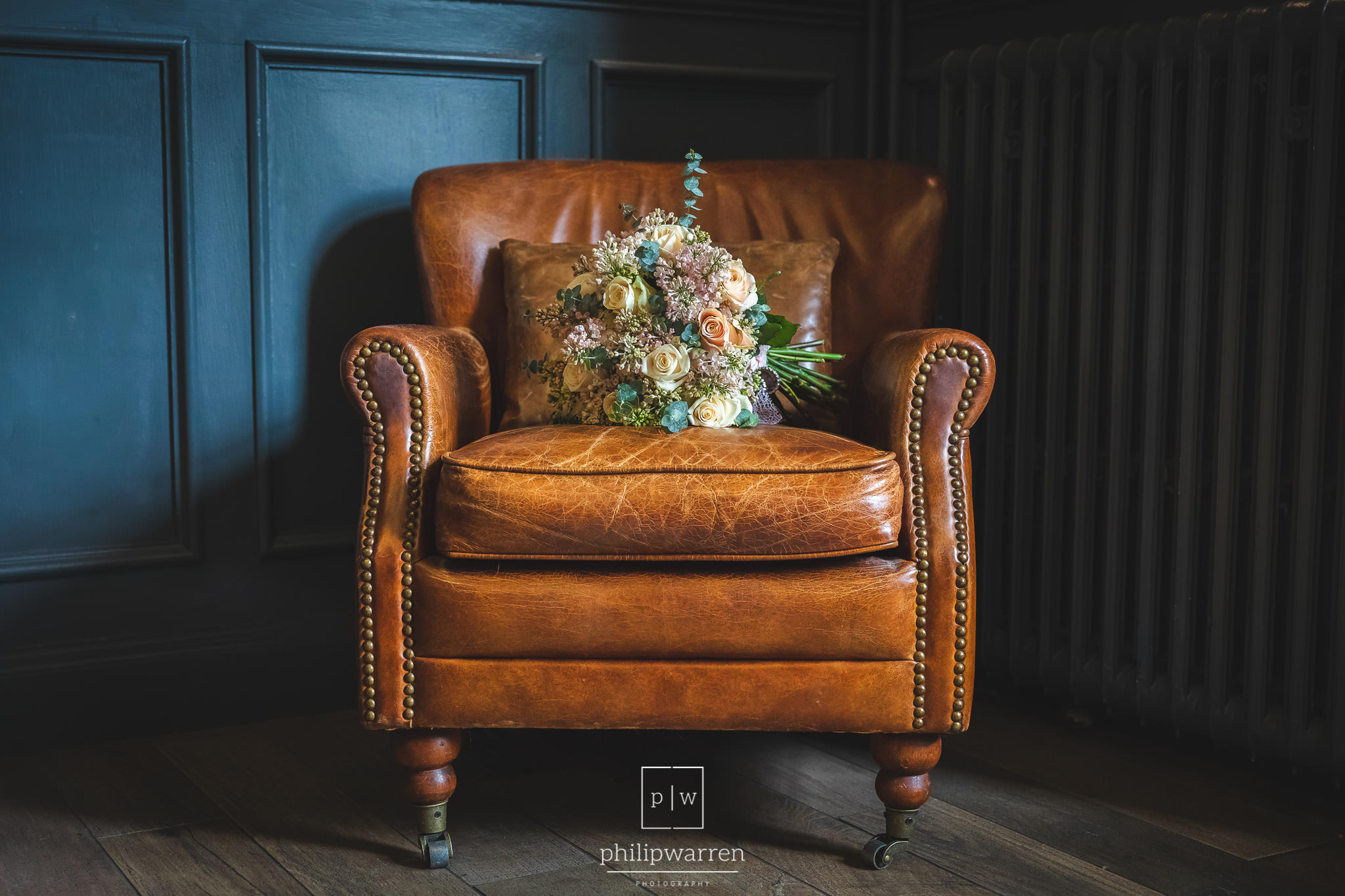 wedding boquet sat on a leather chair in Bryngarw House Hotel