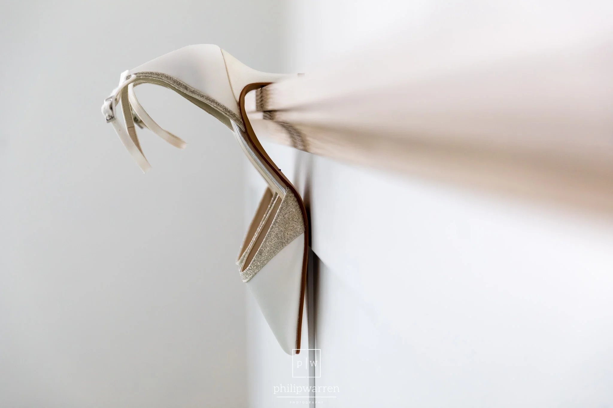 wedding shoes hanging on bed