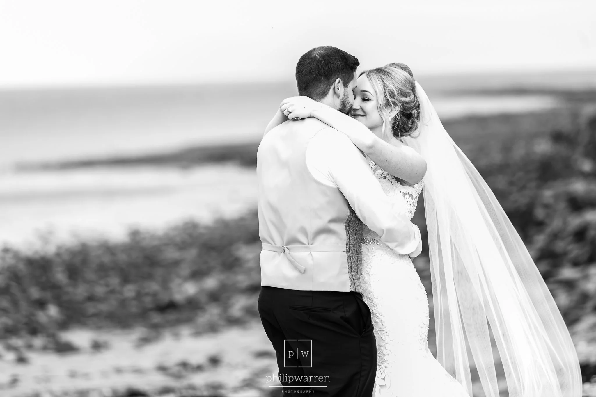 bride and groom hugging on oxwich bay beach