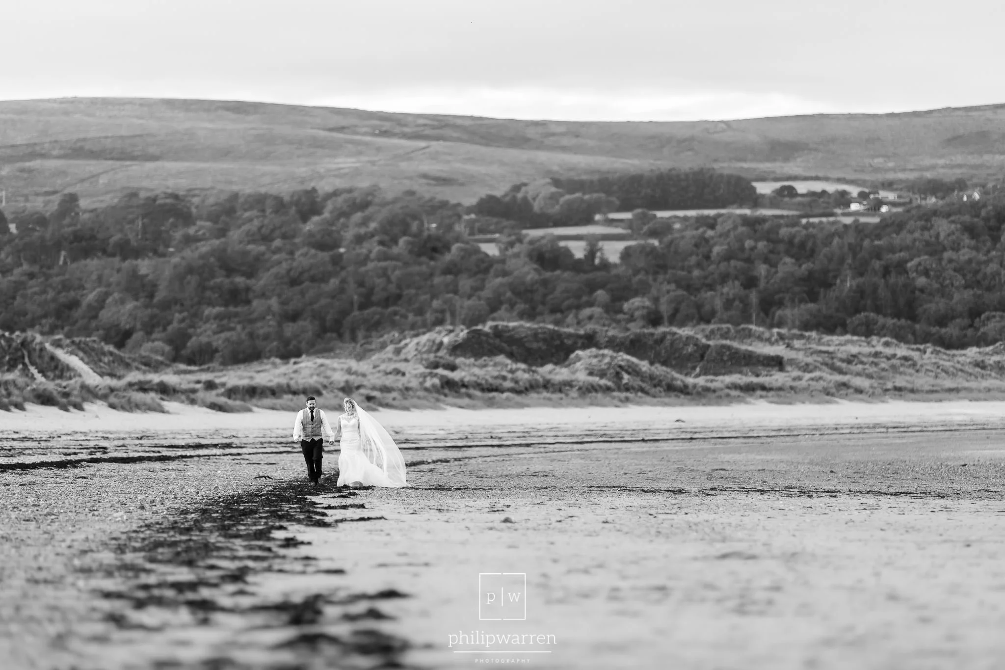 bride and groom walking on the beach