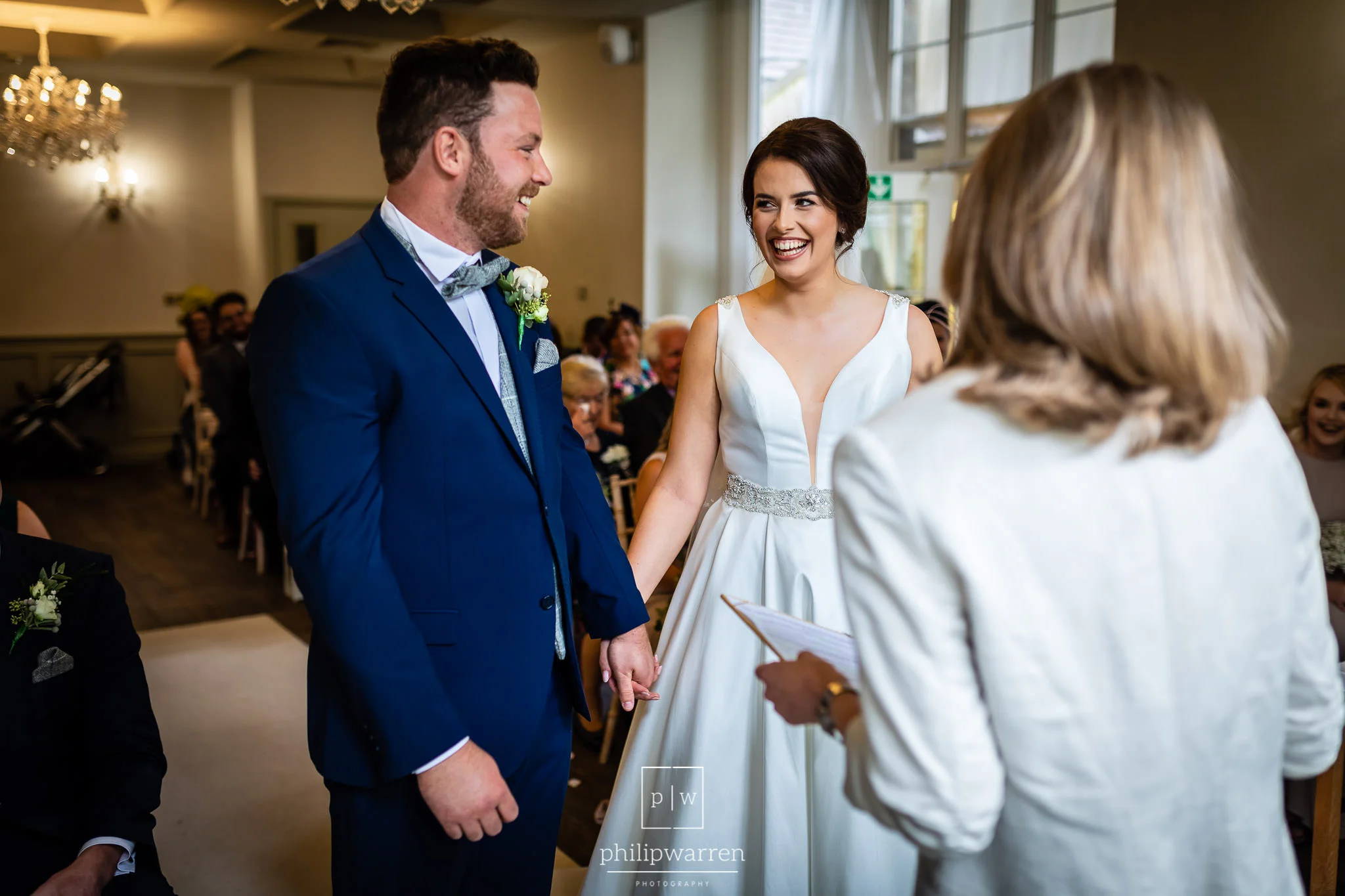 bride and groom laughing at each other during ceremony
