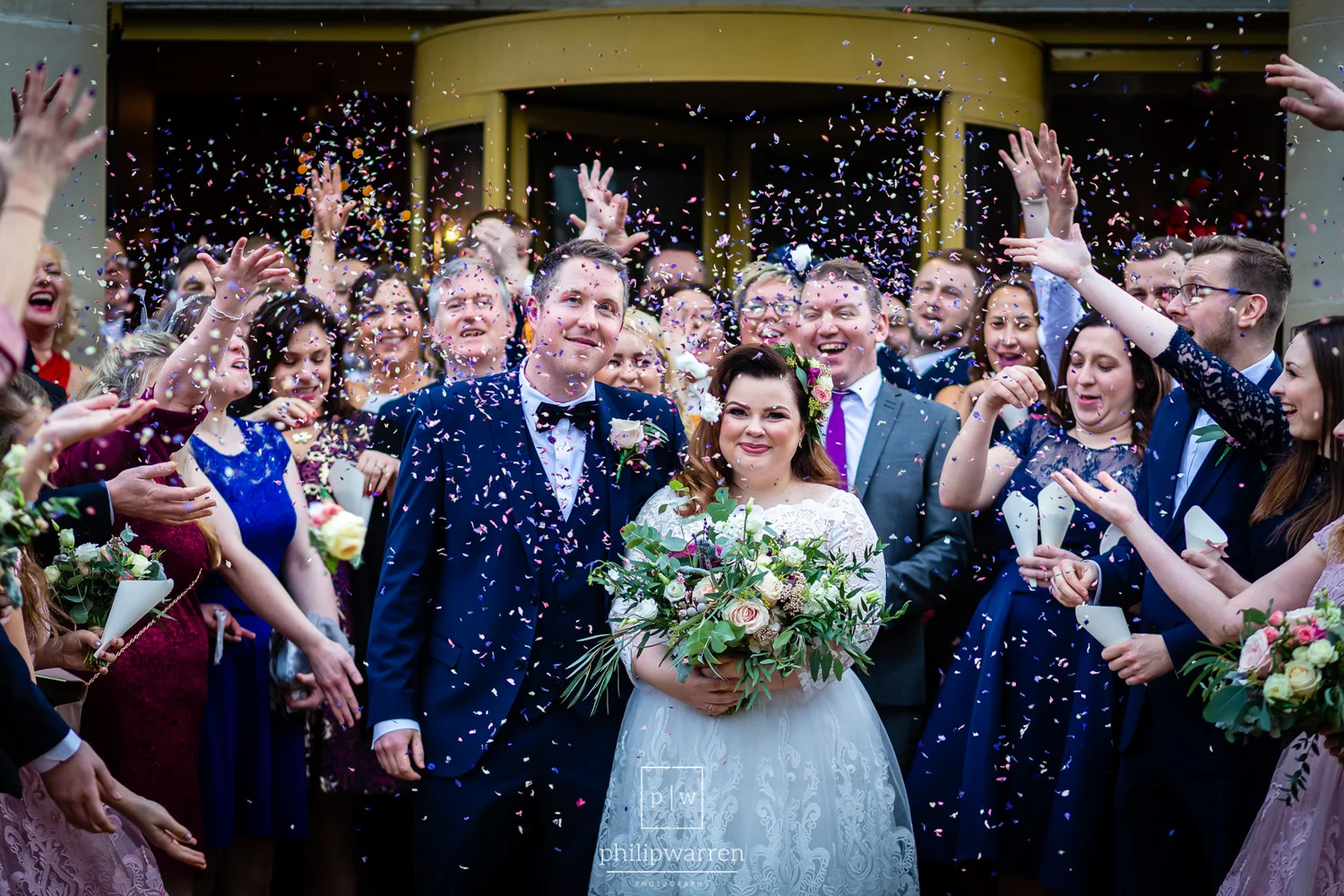 bride and groom having a photo of confetti being thrown