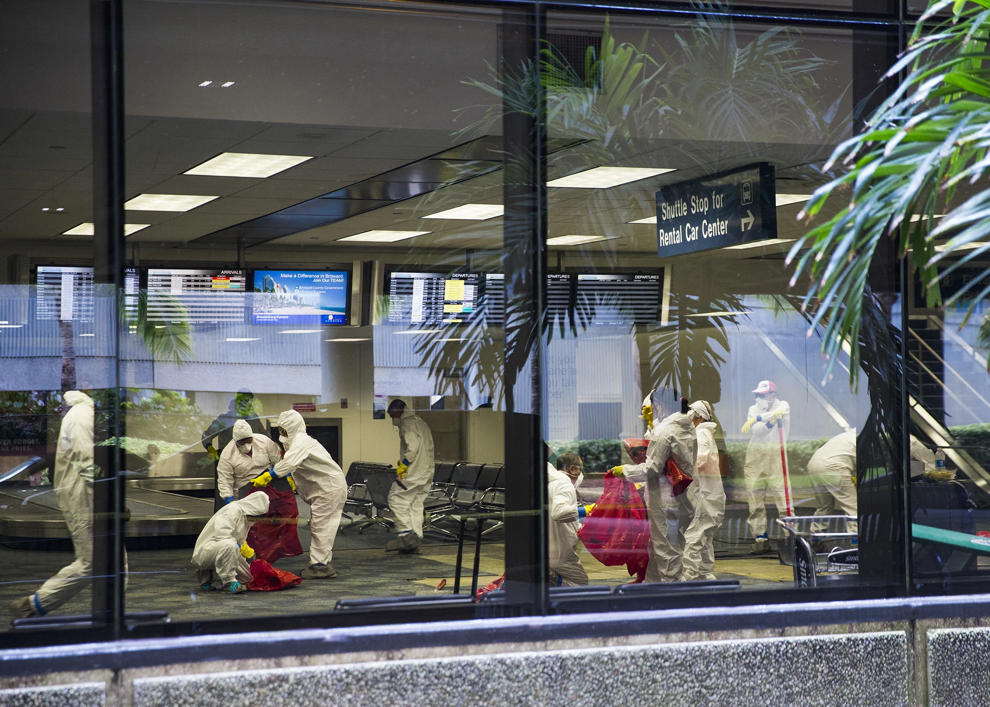 Investigators in hazmat suits gather material in bags inside of the terminal two baggage claim at the Fort Lauderdale - Hollywood International Airport on Saturday, January 7, 2017. Esteban Santiago opened fire on travelers in the terminal two baggage claim the day before.