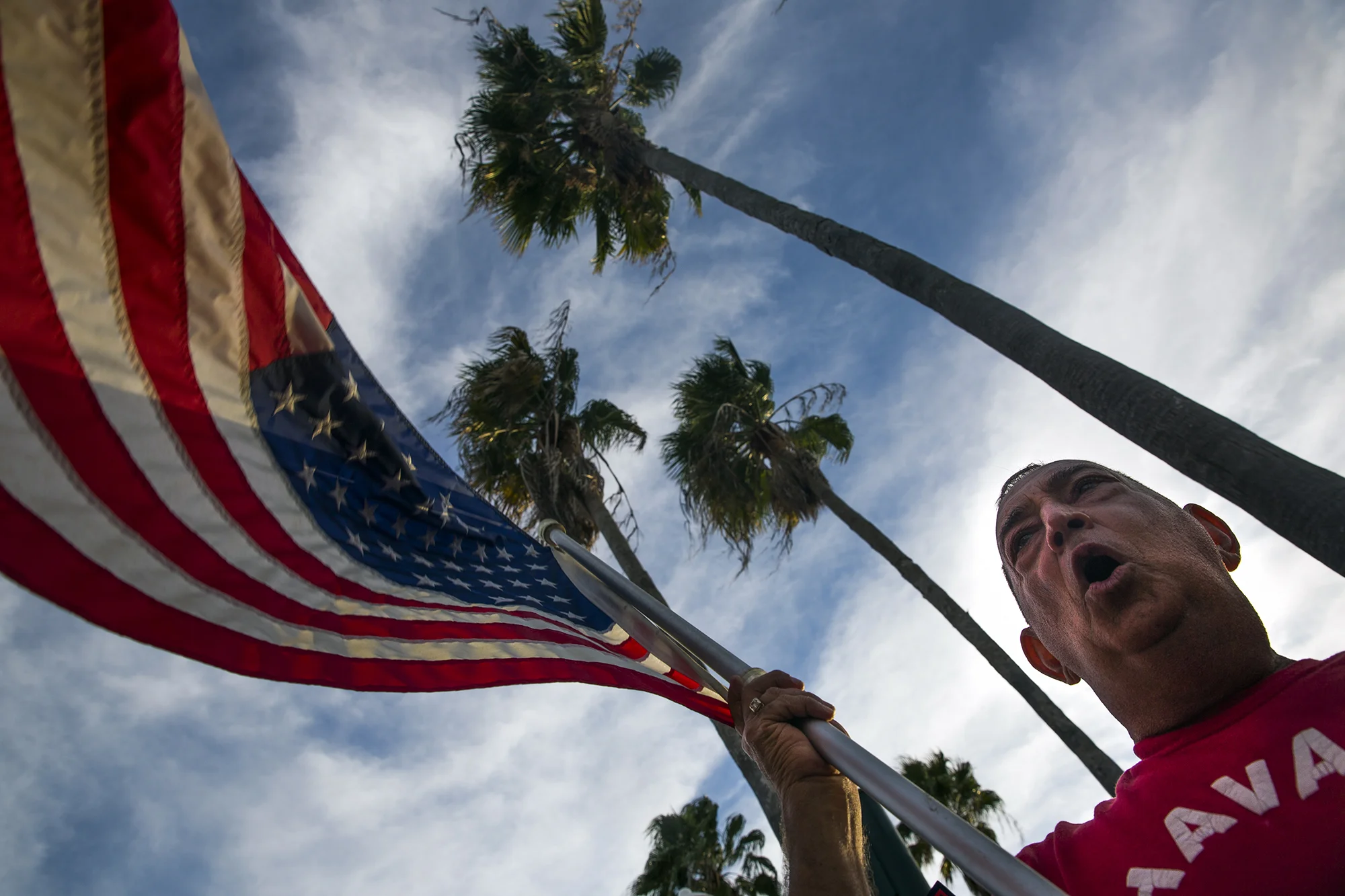 Pedro Blanco waves the Americn flag and cheers into the street on 5th Avenue South on Saturday, November 26, 2016 in the city of Naples. The Cuban community in Naples wished to celebrate the death of Fidel Castro.