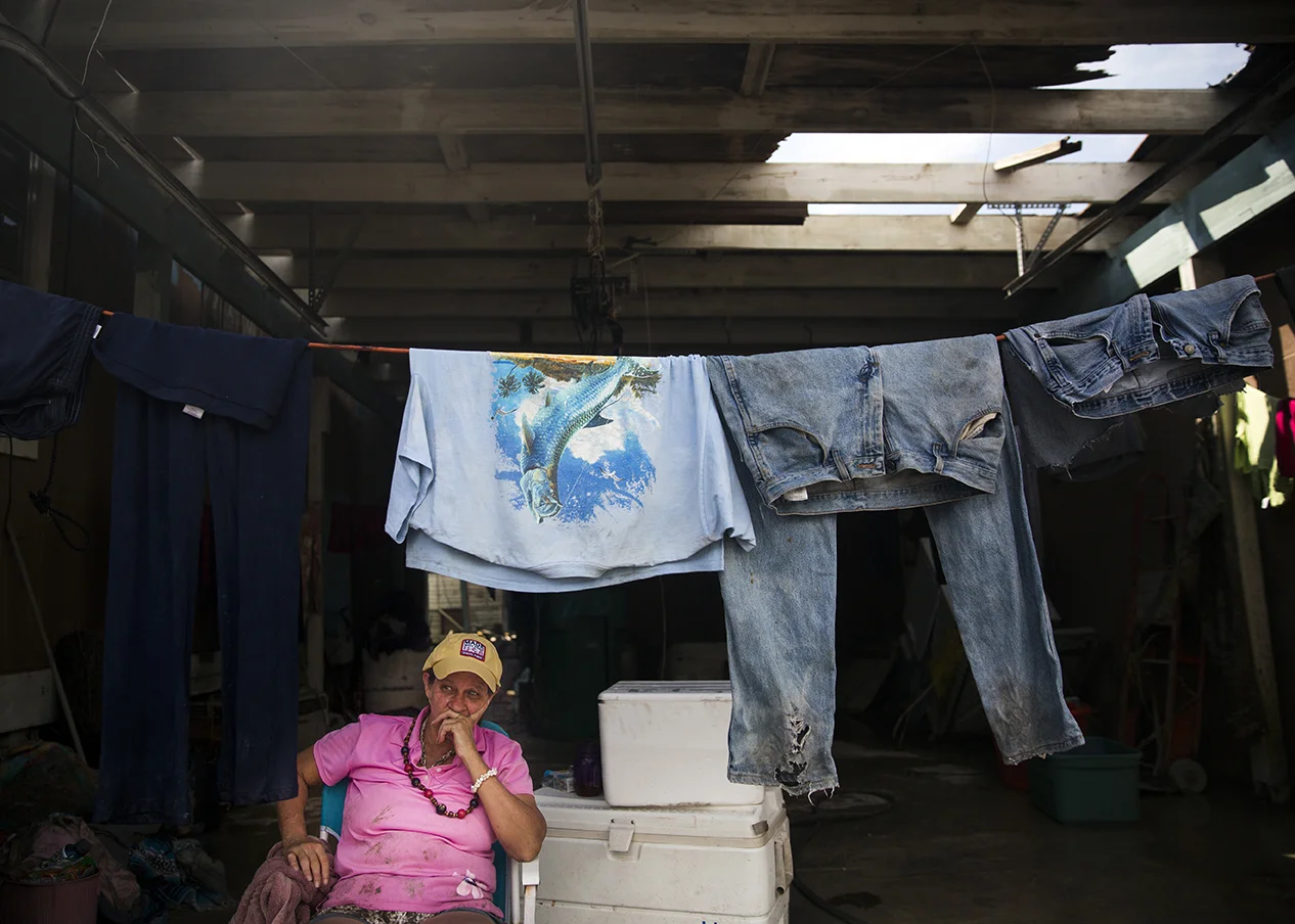 Crystal Holler waits for her clothes to dry in the garage of her neighbor's home in Chokoloskee on Wednesday, September 13, 2017, three days after Hurricane Irma. "All of my clothes came flying out of the house," said Holler. She returned home to find her clothing covered in mud in her yard.