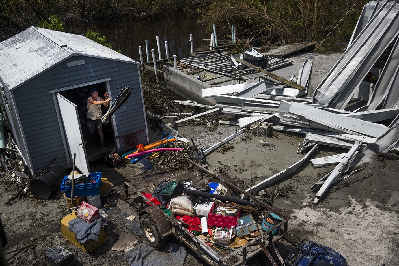 Jacob Daffin starts to throw out items from his grandmother's flooded shed on Thursday, September 14, 2017, four days after Hurricane Irma. 