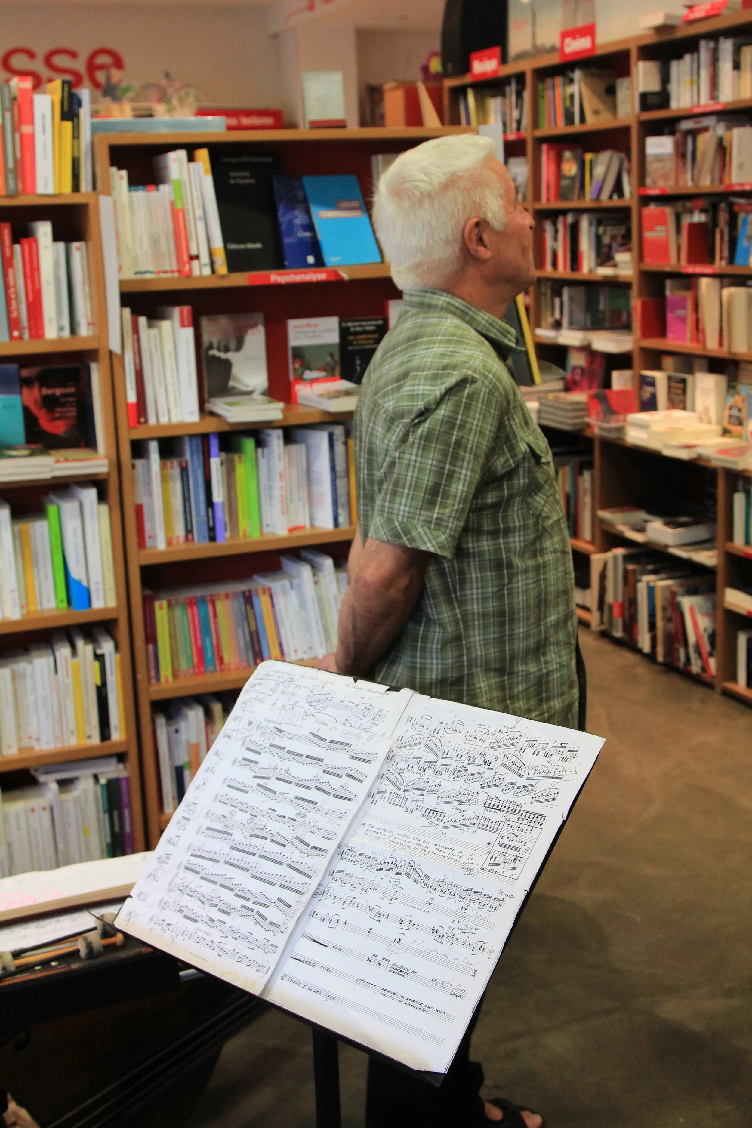 Barry Guy surveys the shelves at Le comptoir des mots prior to his performance with Maya Homburger. Photo: Dan Gunn.