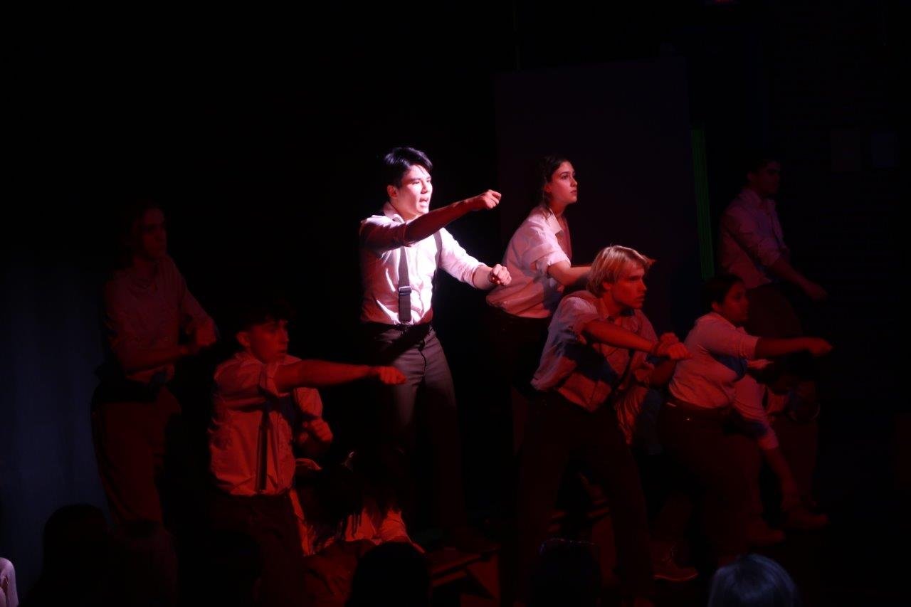  Actors in white shirts and suspenders holding out their hands as they prepare to charge in this scene. 