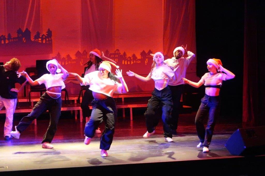  Dancers in white tops and black pants in the foreground 