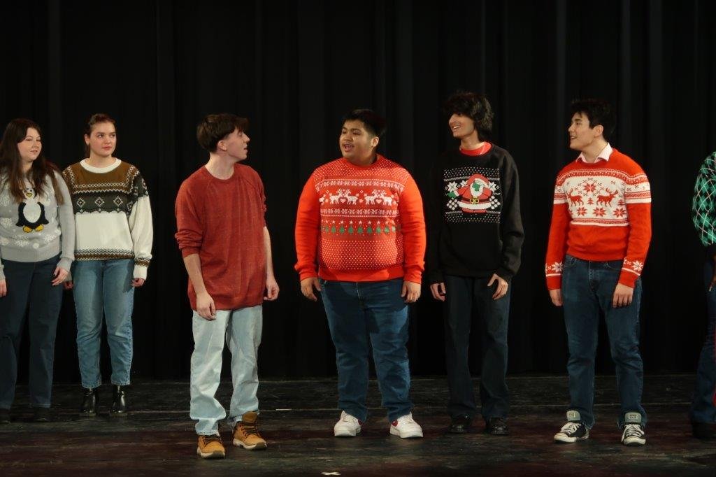  Group of singers singing against a black backdrop. 