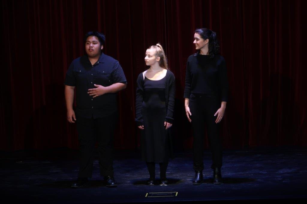  Narrators dressed in dark colours against a black background. 